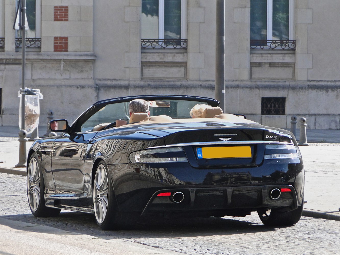 Rear view of a convertible with dual exhaust and alloy wheels