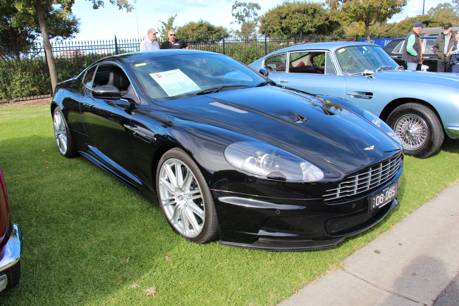 Front-side view of black sports coupe with sleek grille and alloy wheels.