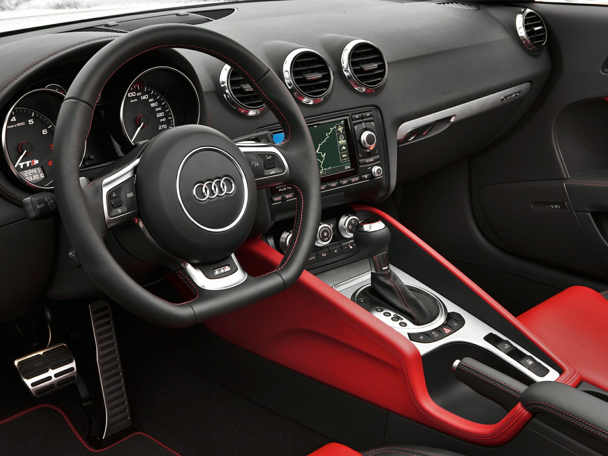 Sporty steering wheel and red-trimmed center console with gear shift