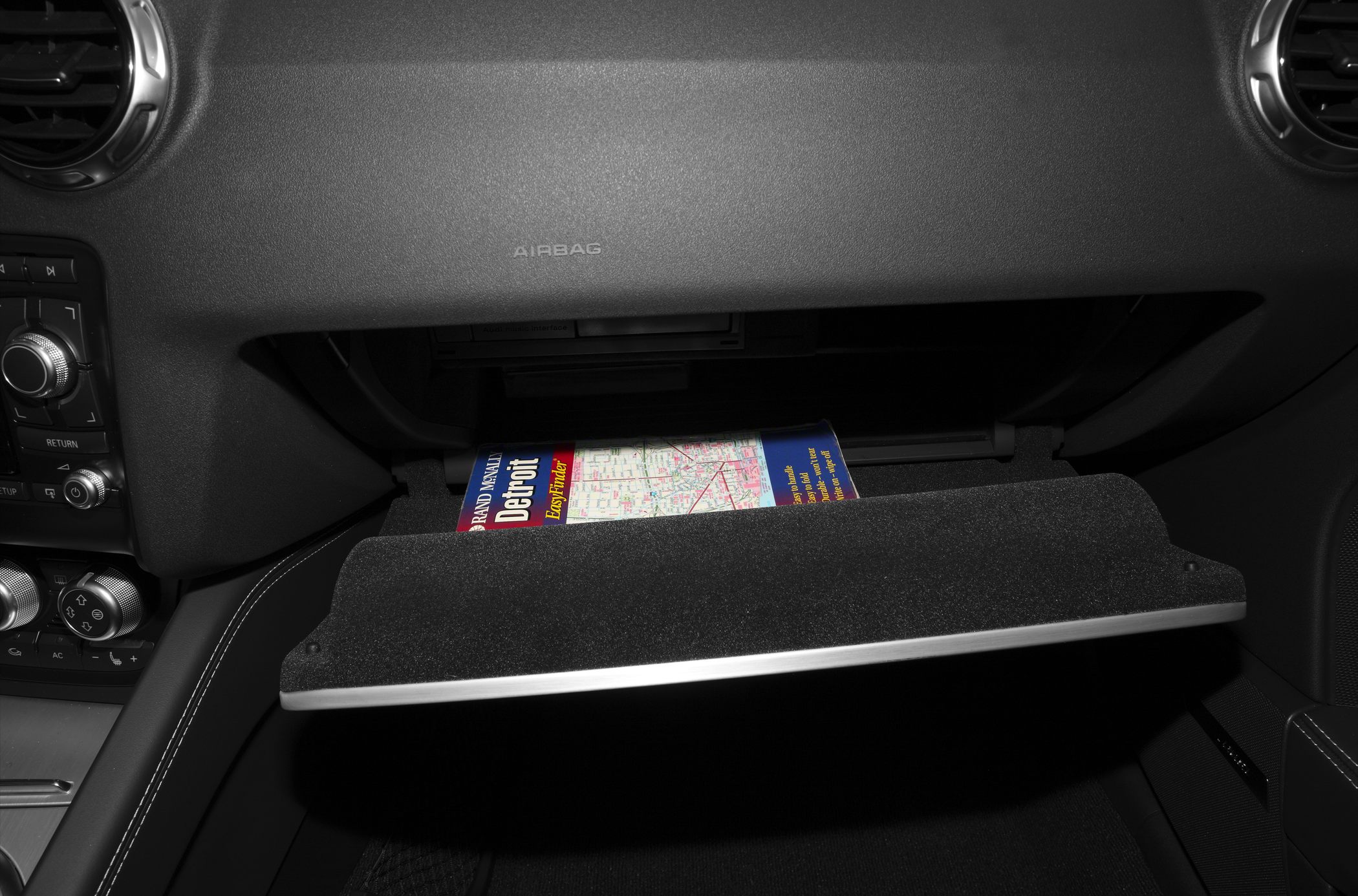 Open glovebox with a map inside in car interior