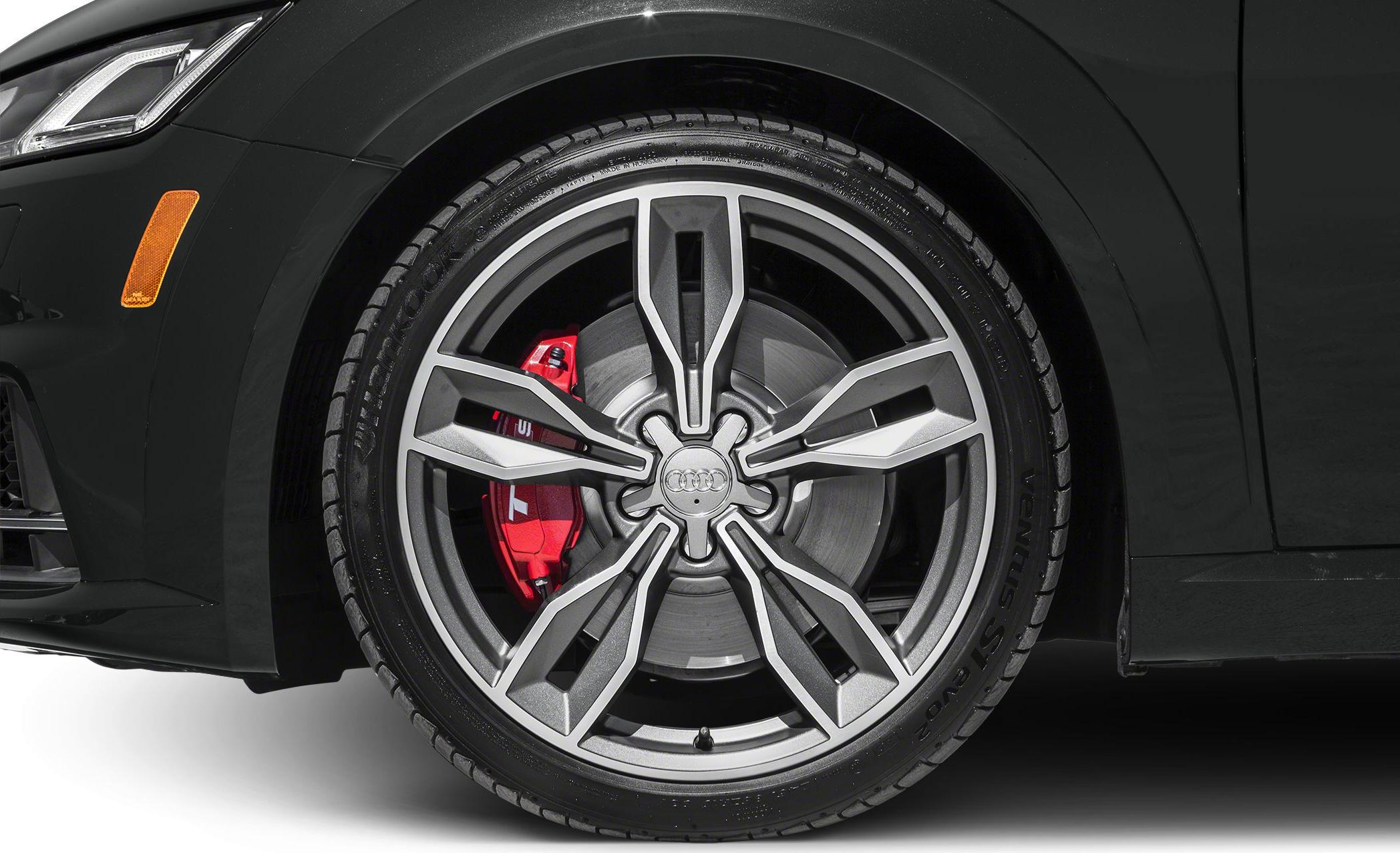 Close-up of alloy wheel with red brake caliper and tire tread