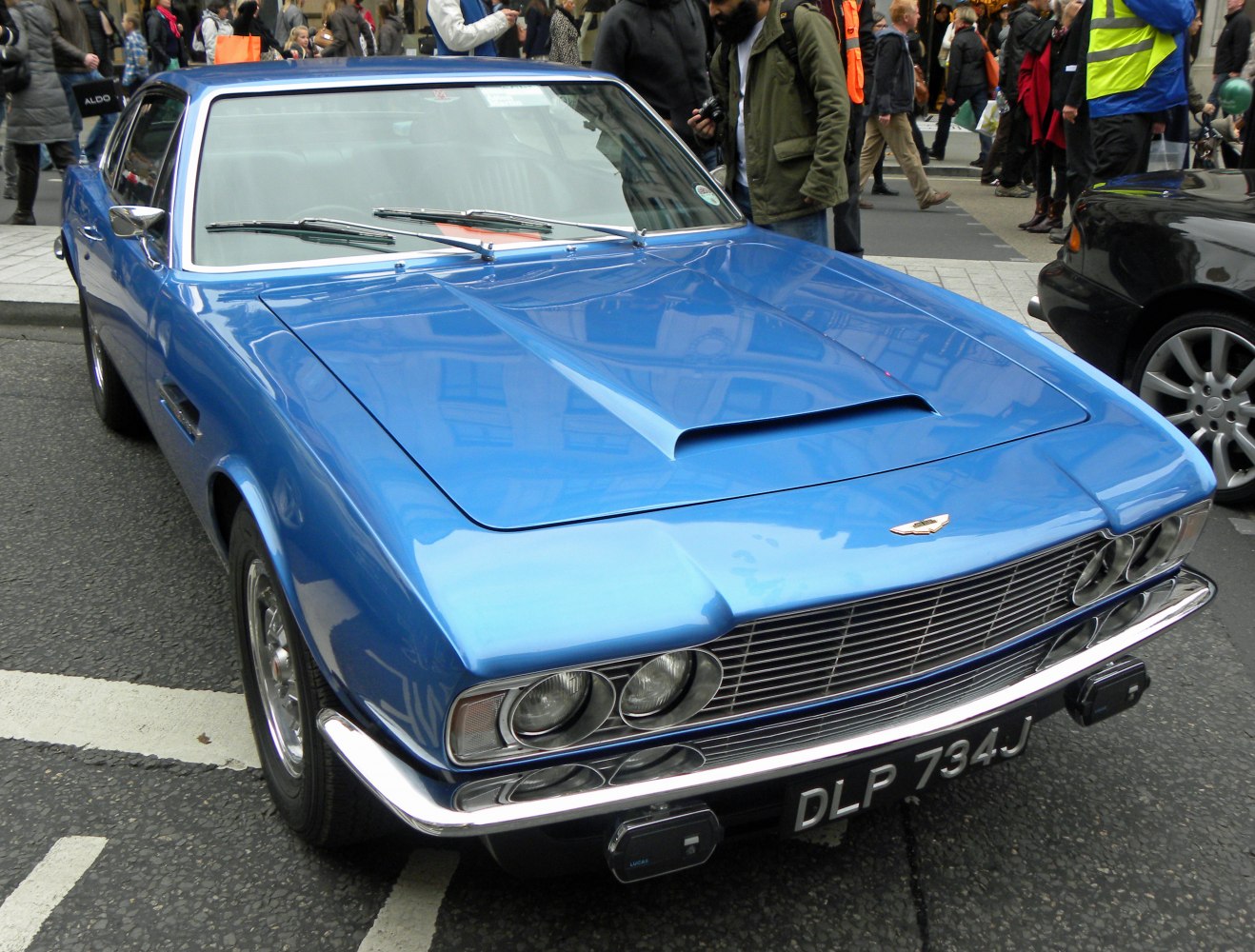 Front view of vintage muscle car with dual round headlights and hood scoop