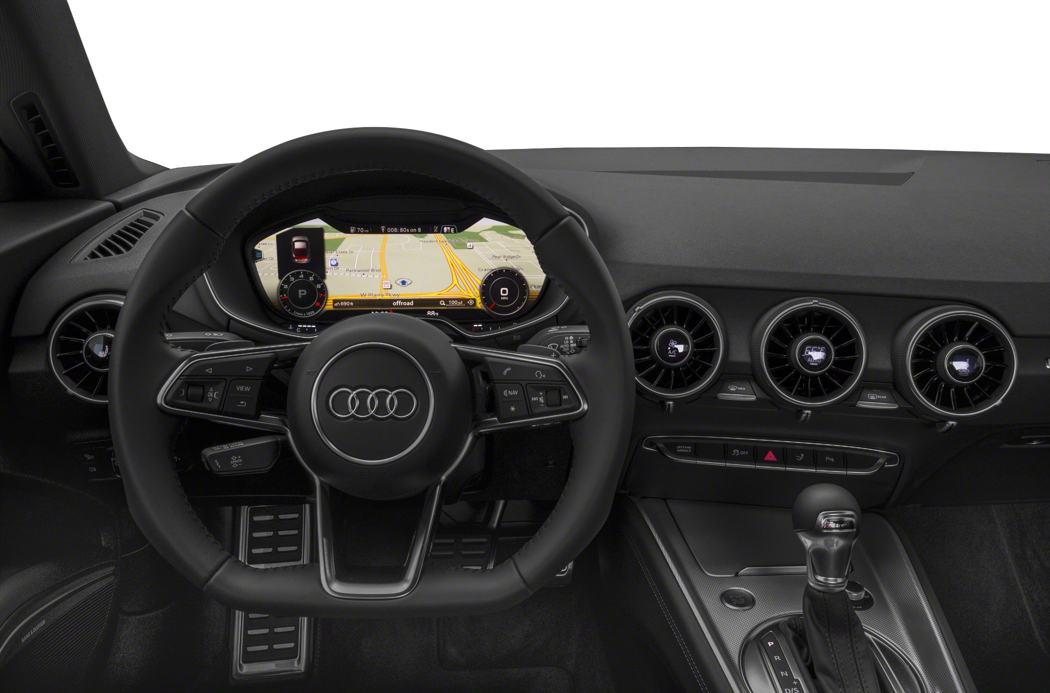 Steering wheel with Audi logo, digital instrument cluster, round air vents, and gear shift lever.