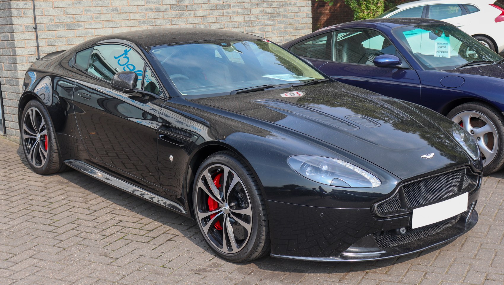 Sleek black coupe with sporty alloy wheels and aerodynamic front grille