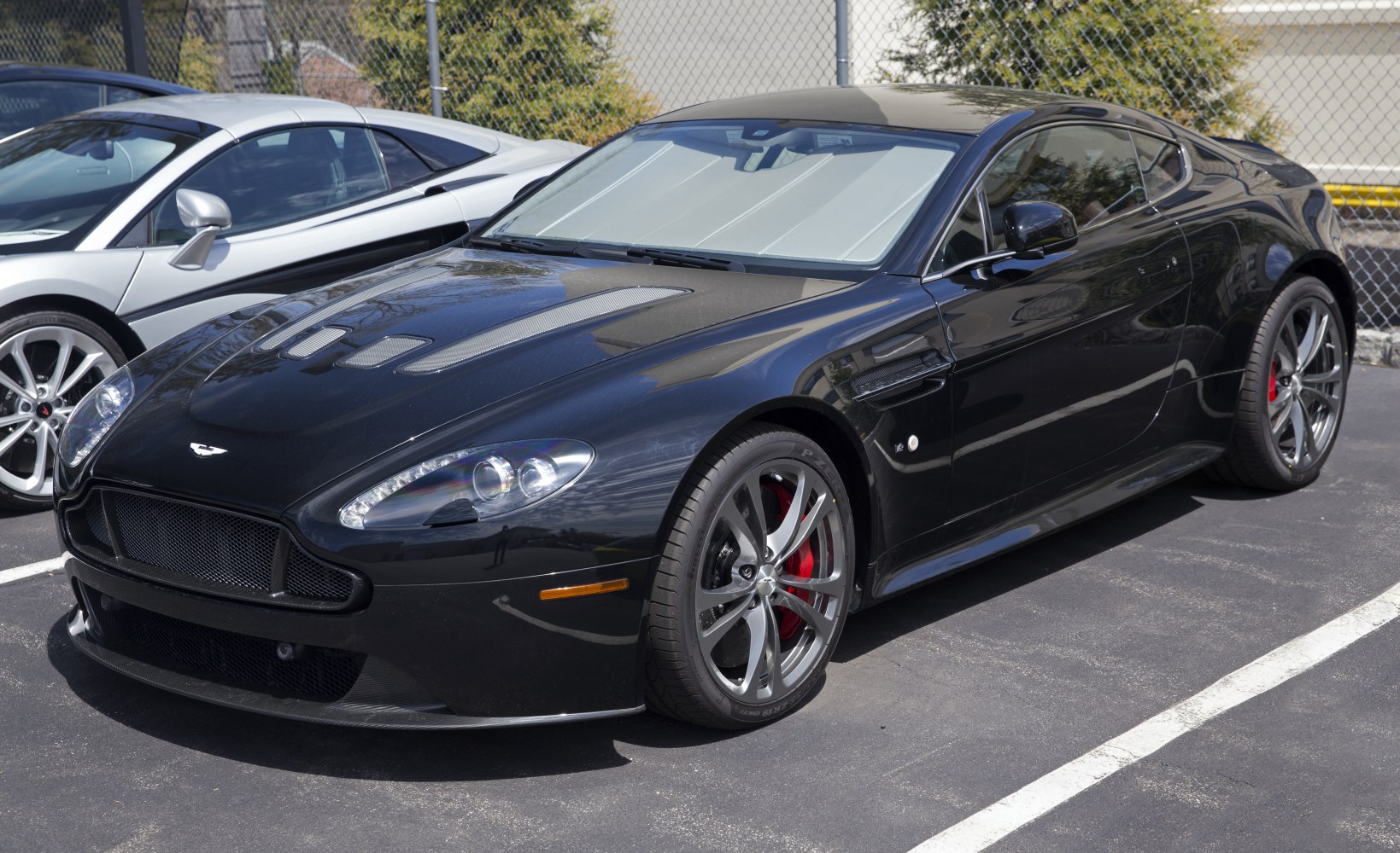 Front side view showing carbon fiber hood vents and alloy wheels