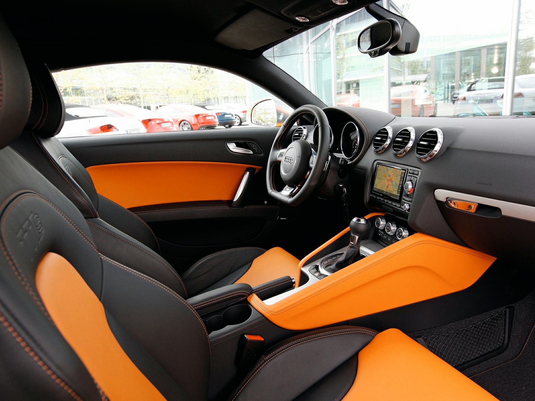 Sporty car interior with orange upholstery and detailed dashboard