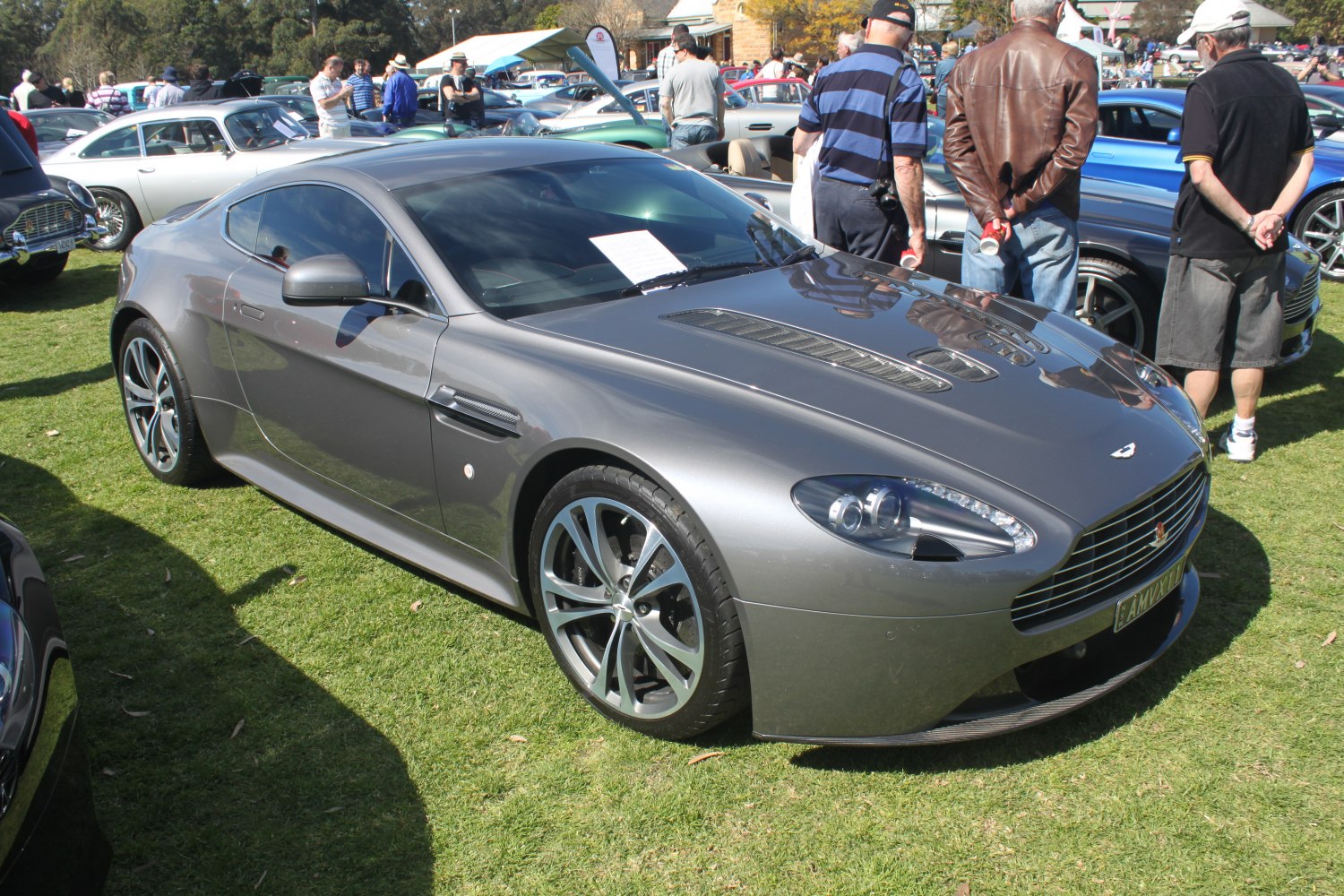 Gray sports coupe with hood vents and alloy wheels shown from front quarter view.