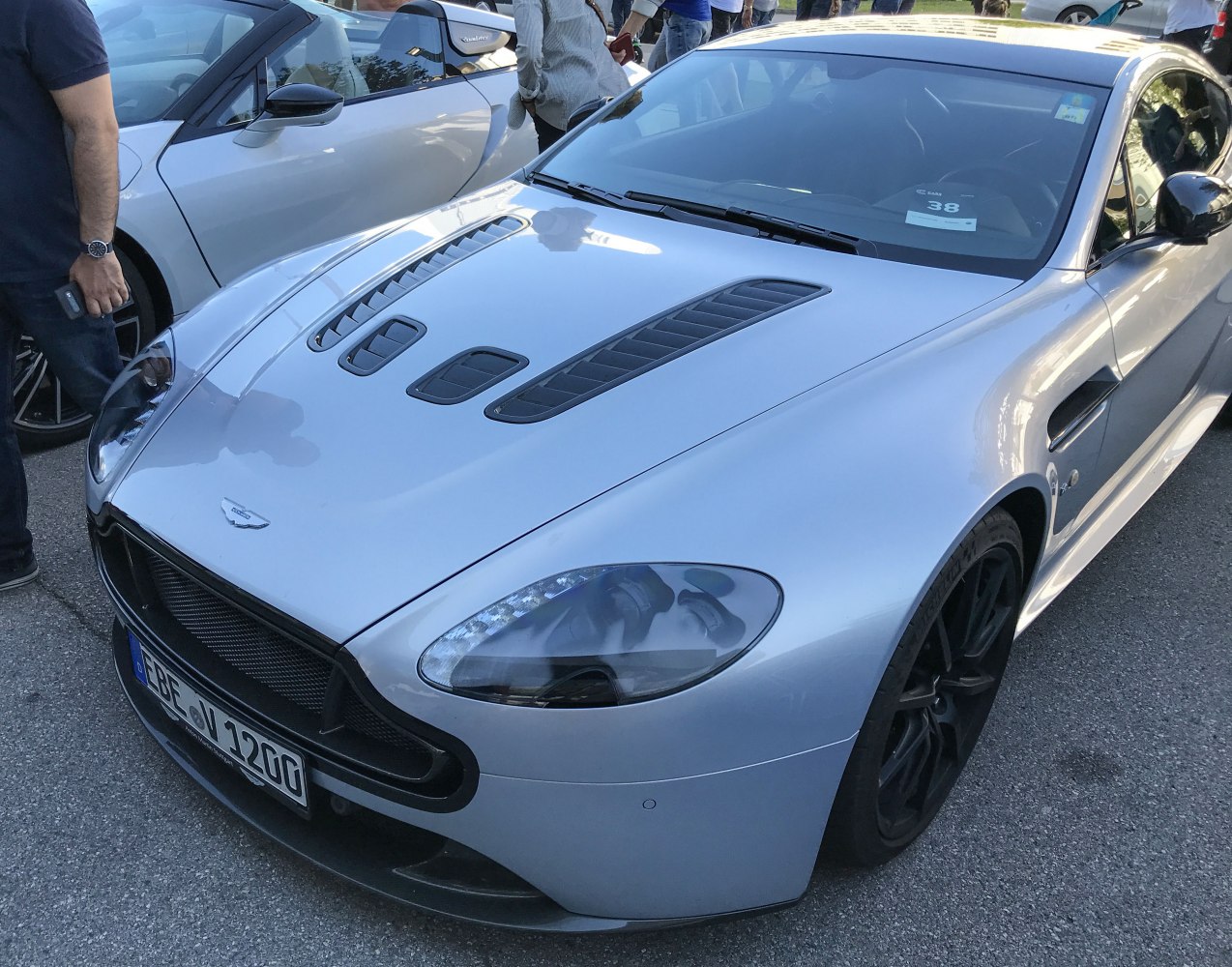 Silver sports coupe with aggressive hood vents and black wheels