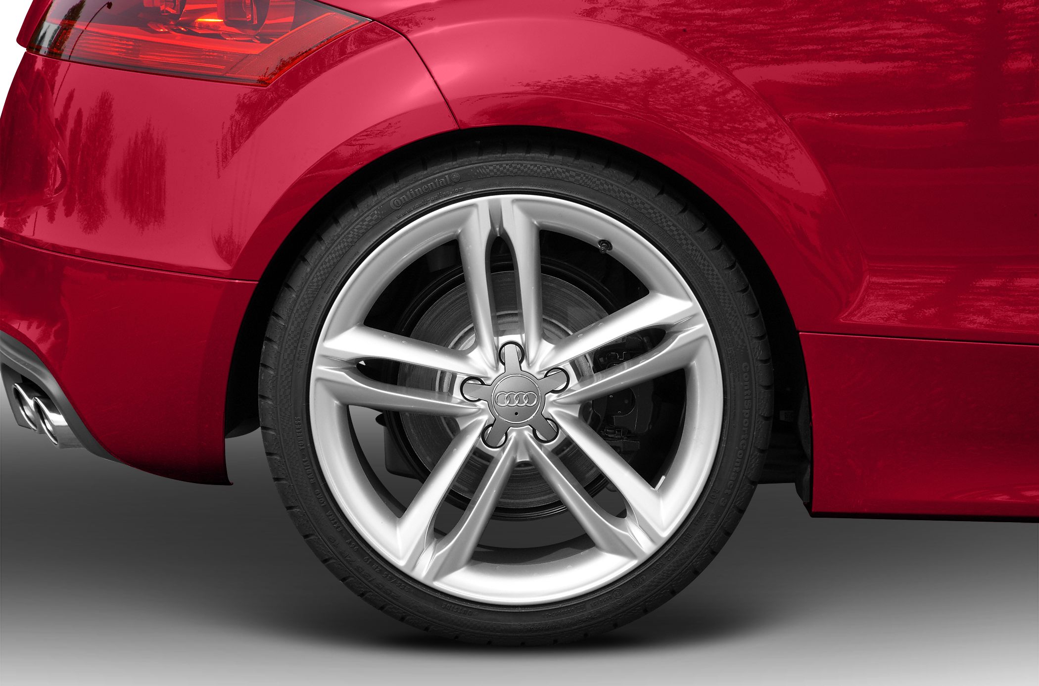 Close-up of alloy rear wheel and red taillight