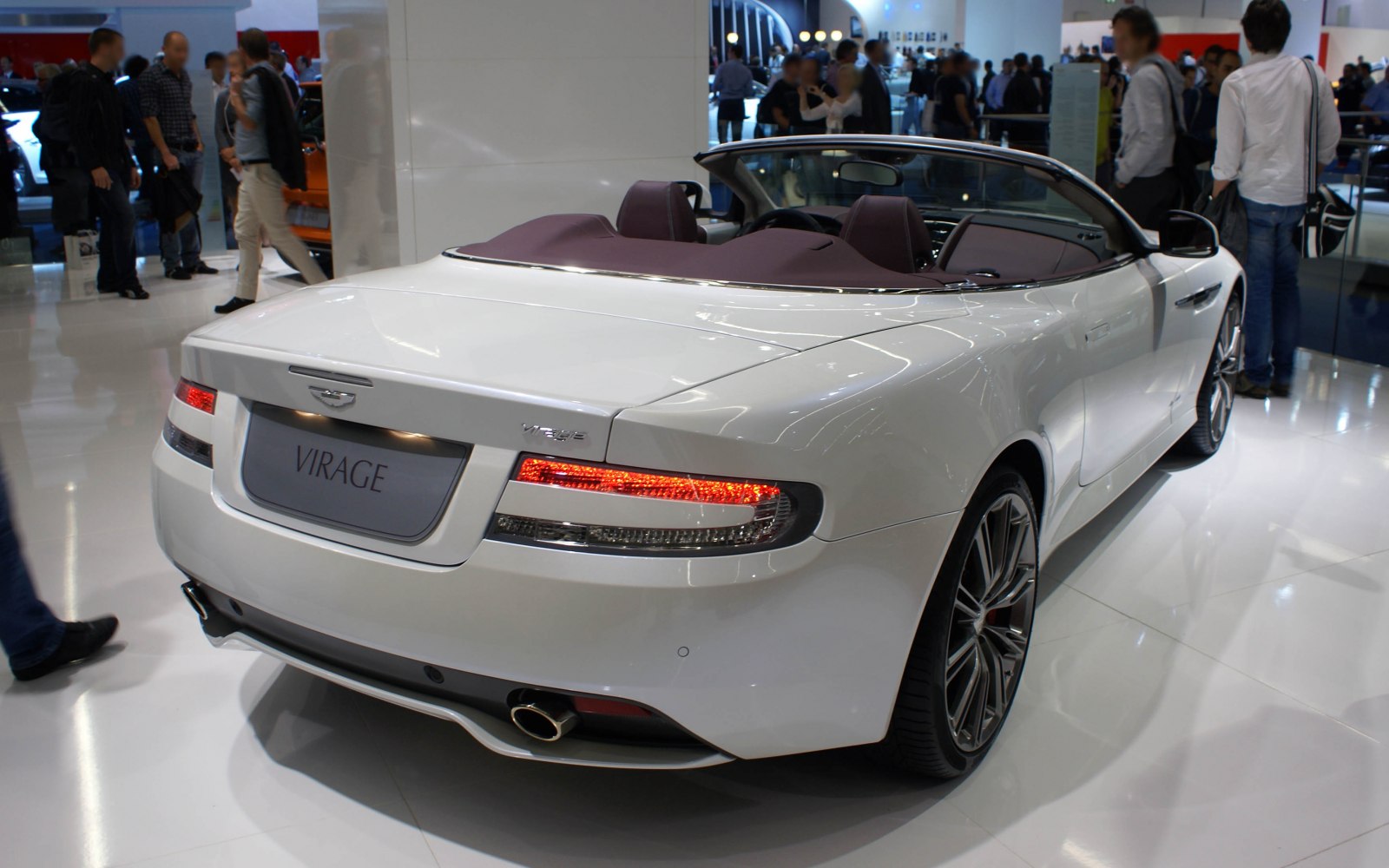 Rear view of a white convertible with distinctive taillights and dual exhaust.