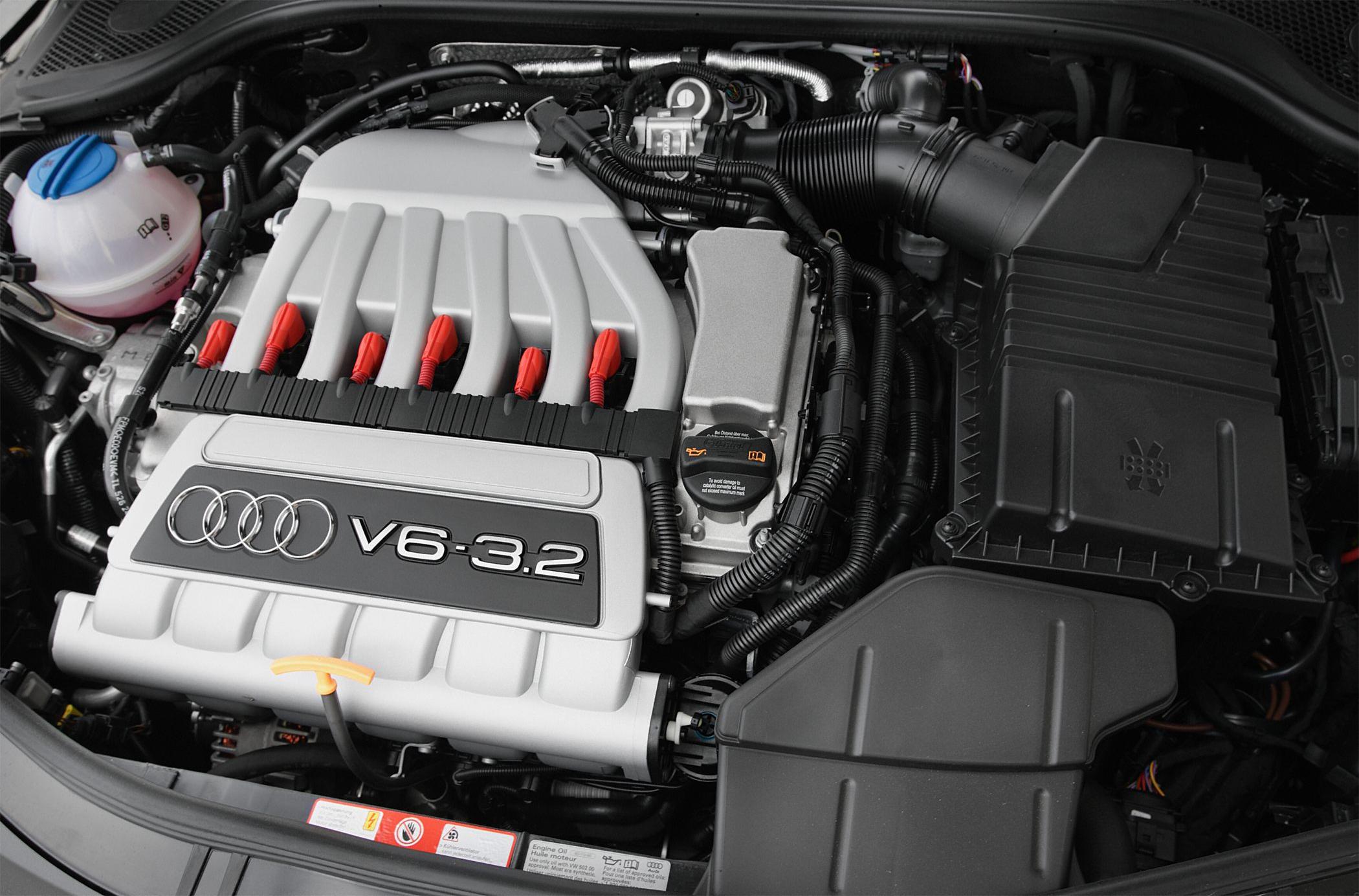 Close-up of 3.2L V6 engine with red ignition coils and air intake components.