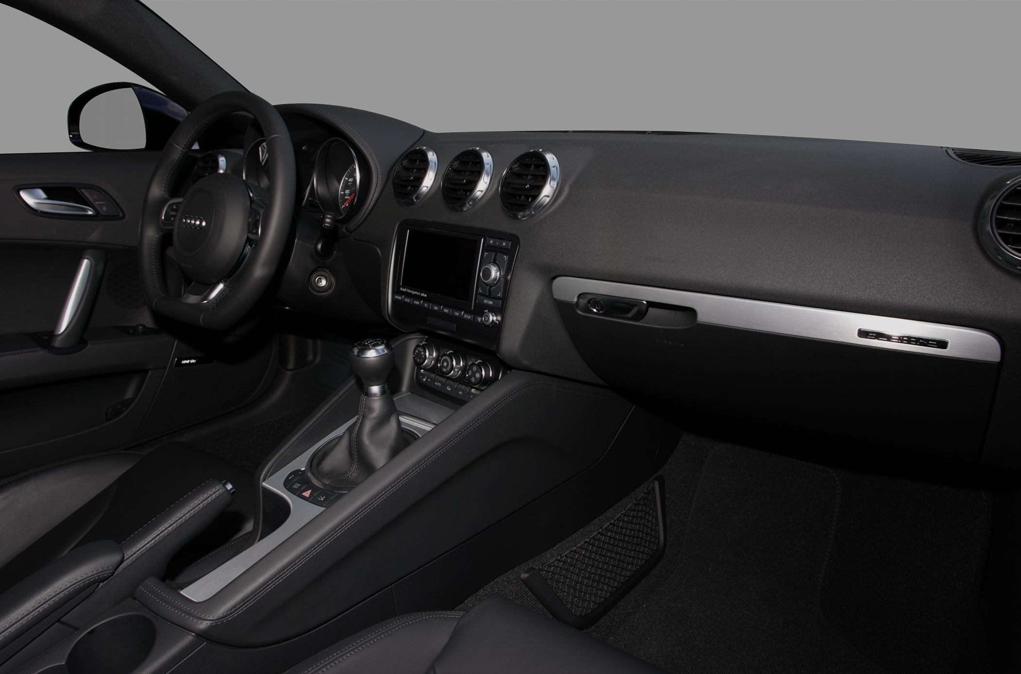 Steering wheel, manual gear shift, dashboard with air vents and multimedia controls