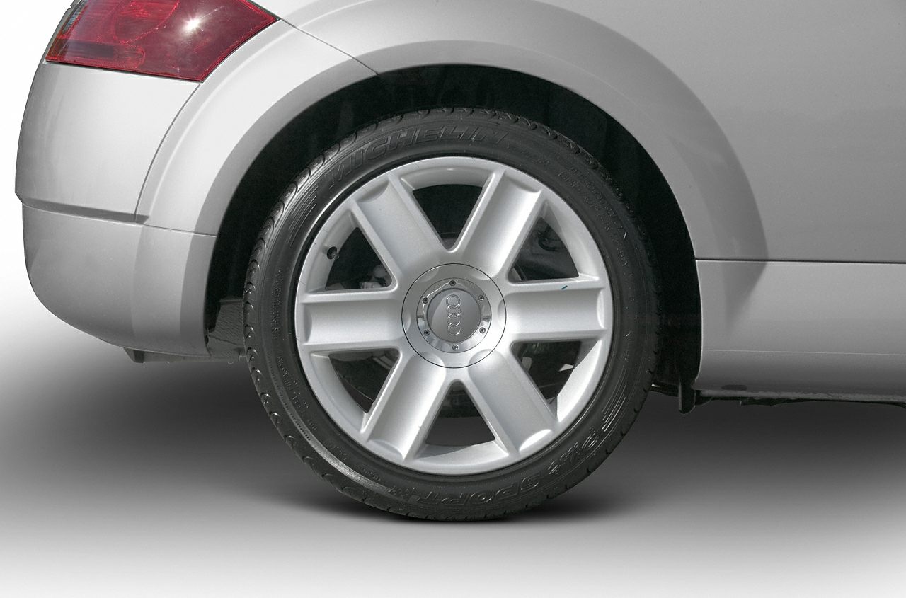 Silver 6-spoke alloy wheel with Michelin tire on rear section of vehicle
