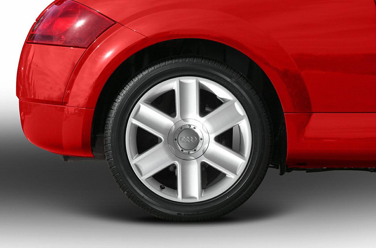 Rear wheel with alloy rim and distinctive tail light of a sports coupe.