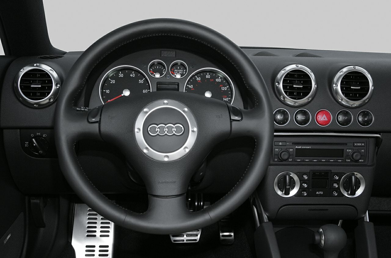 Audi TT 8N facelift interior with round vents and multifunction steering wheel.
