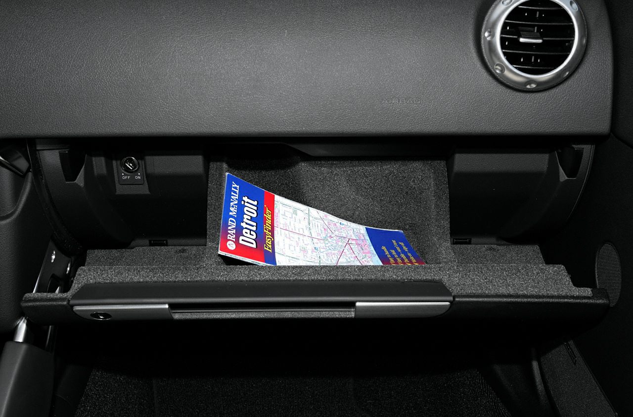 Open glove compartment with map inside and round air vent