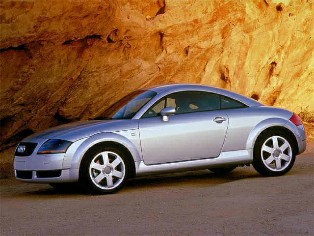 Silver two-door coupe with rounded design and alloy wheels in side profile.