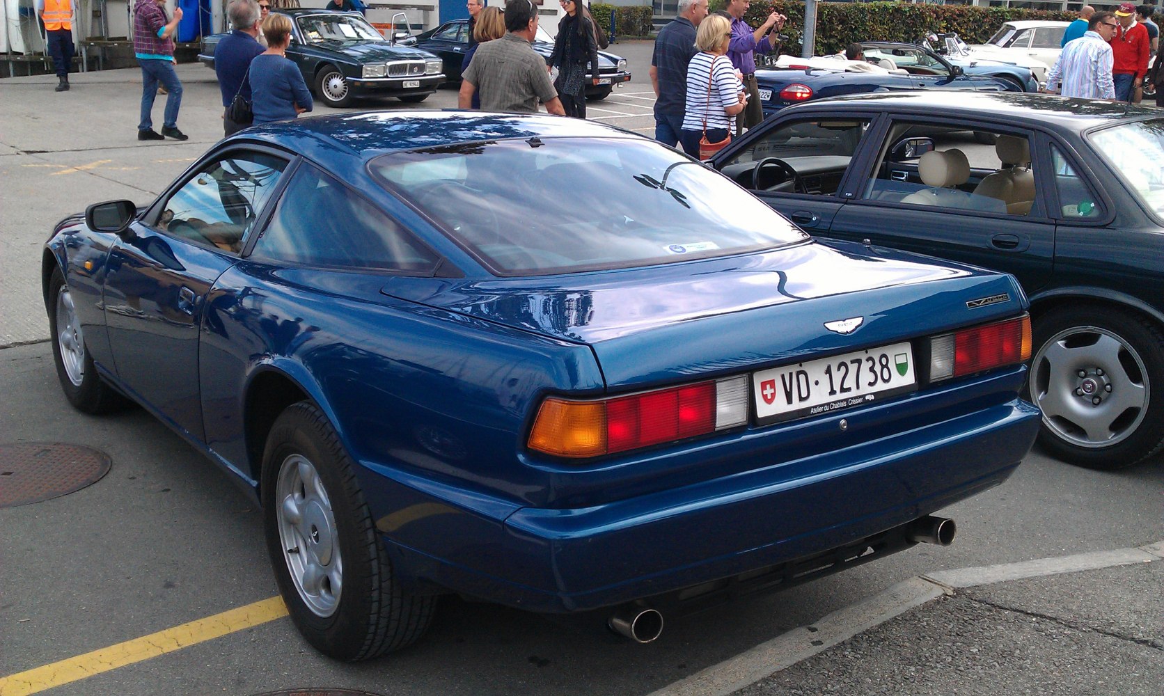 Rear view of a 1990s luxury sports coupe with distinct taillights and dual exhaust.