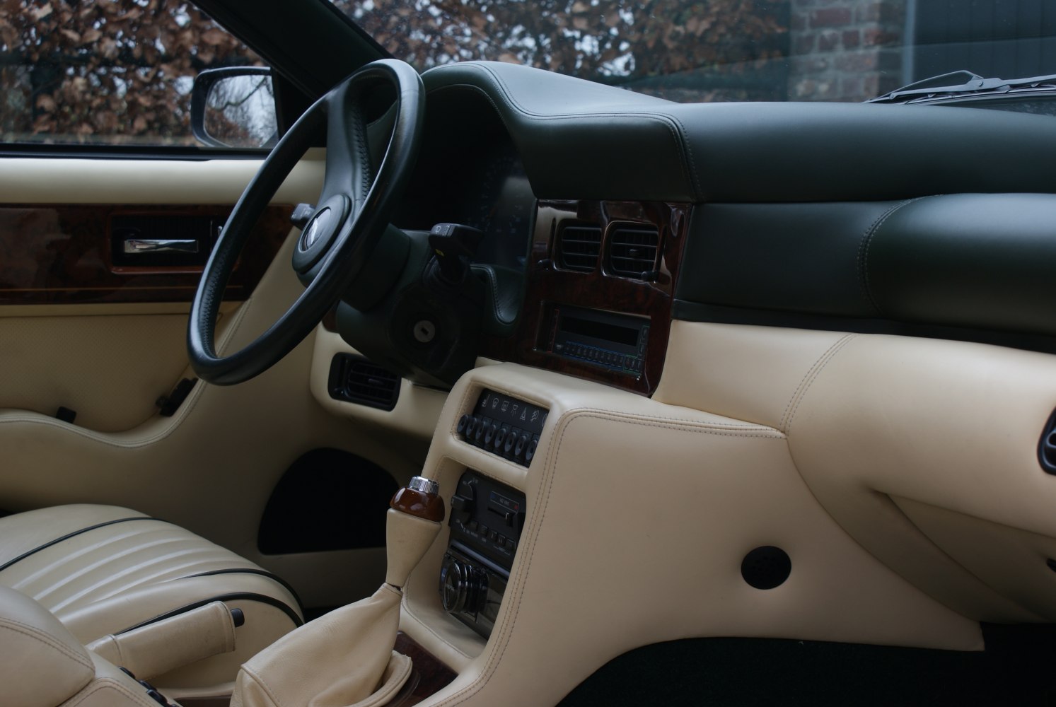 Luxury vintage car interior with leather and wood trim dashboard.