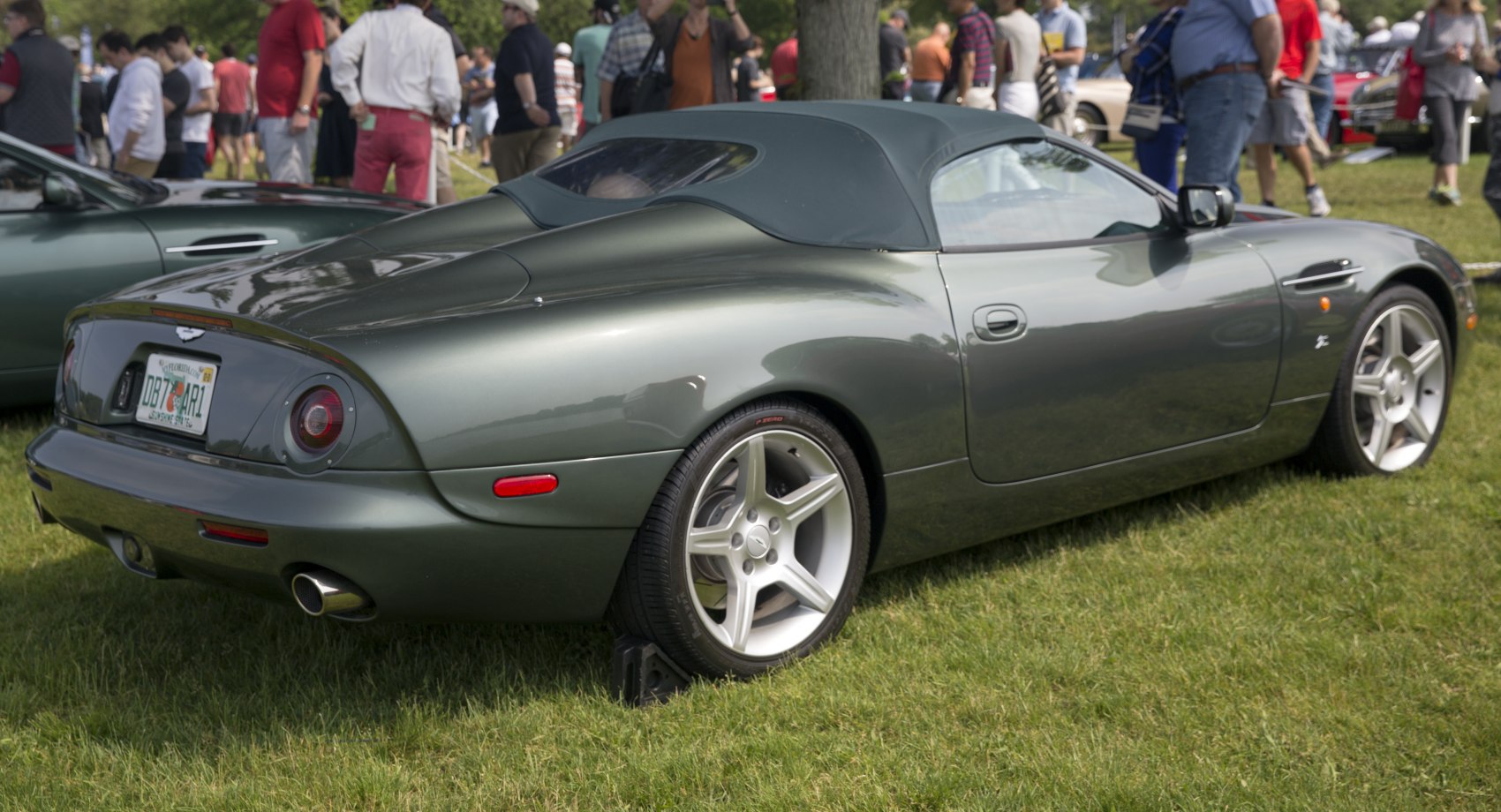 Rear side view of a convertible with alloy wheels on grass.