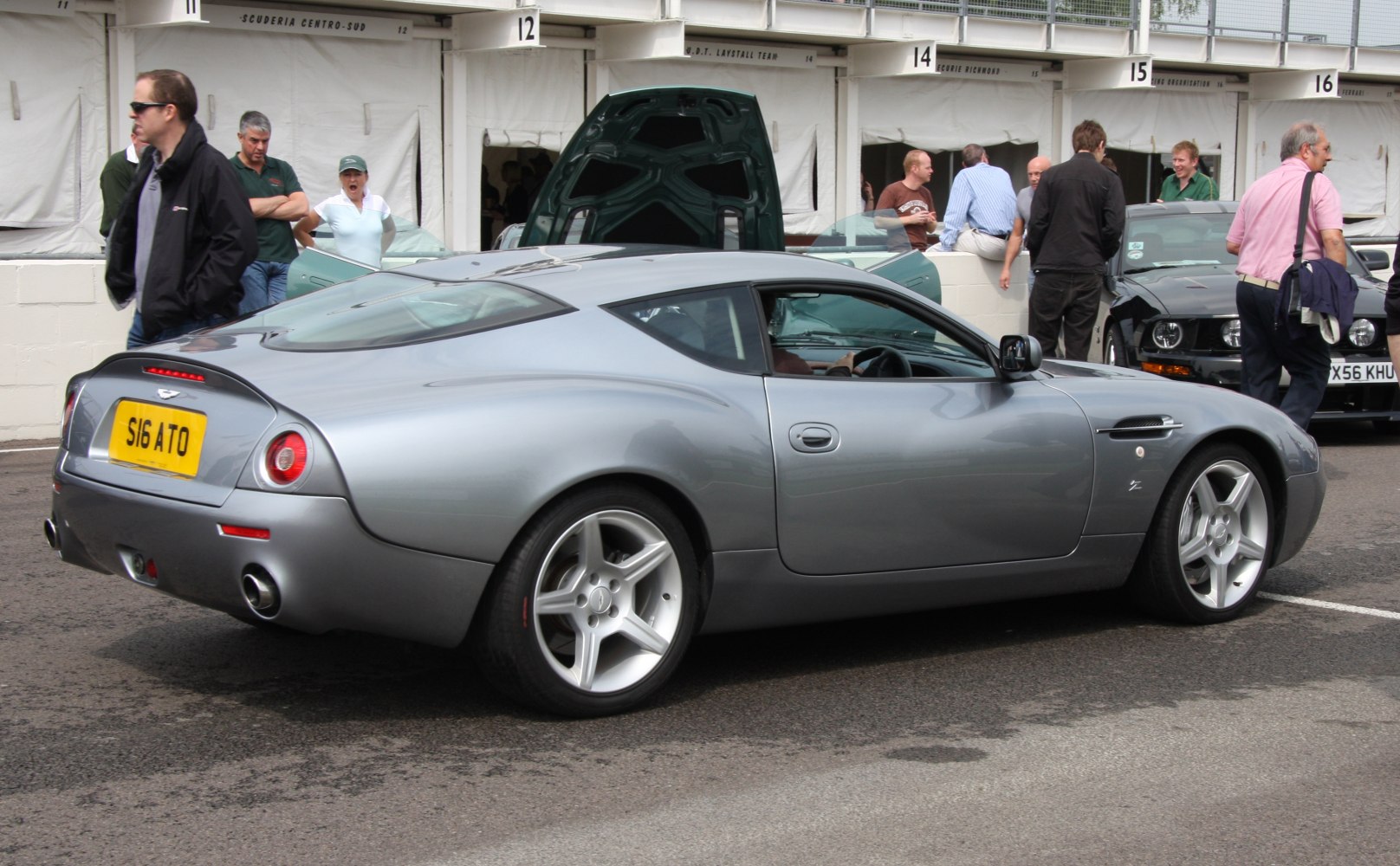 Silver coupe rear side view with round taillights and dual exhausts