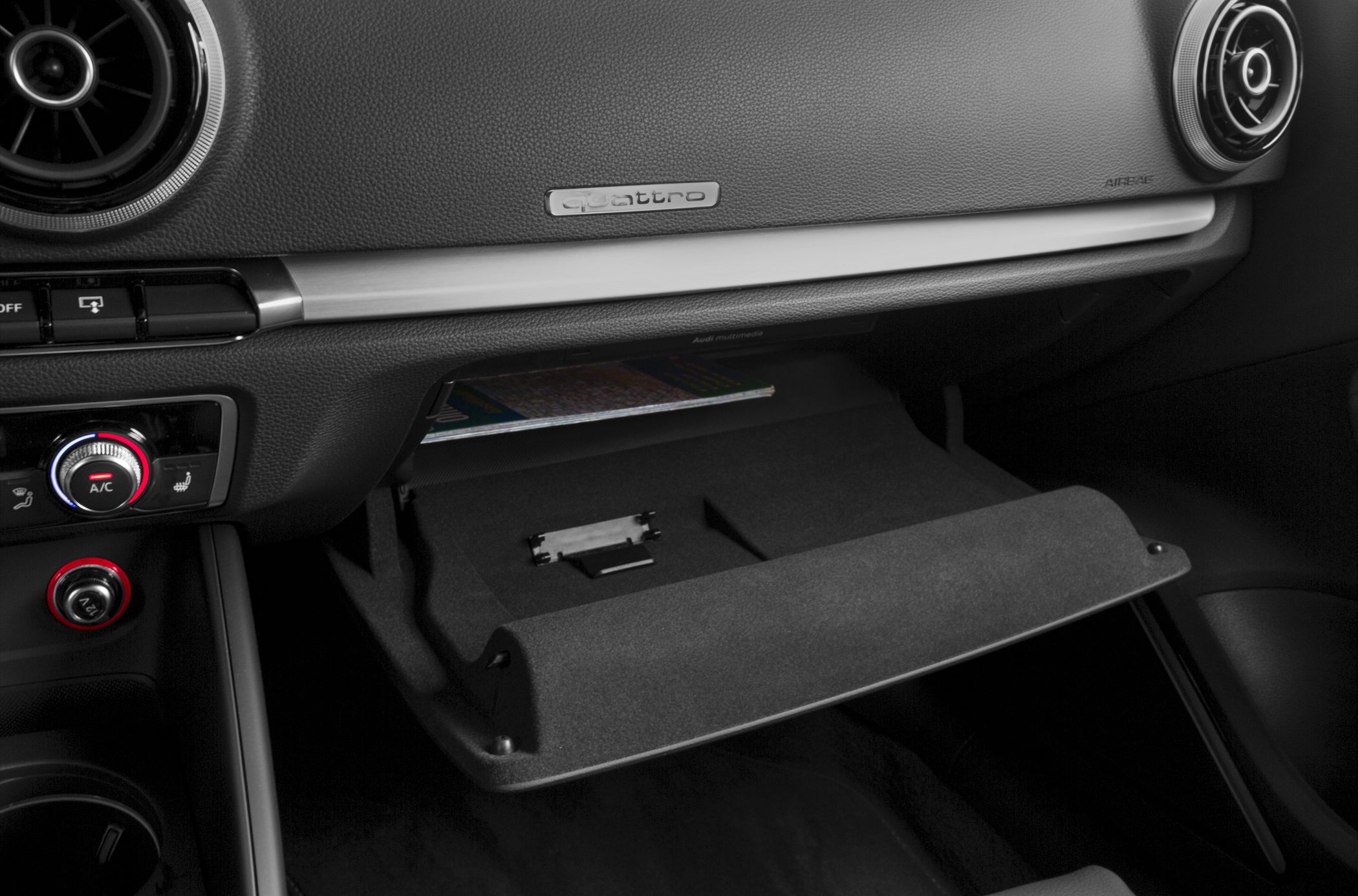 Open glove box, circular air vents, dashboard with quattro badge