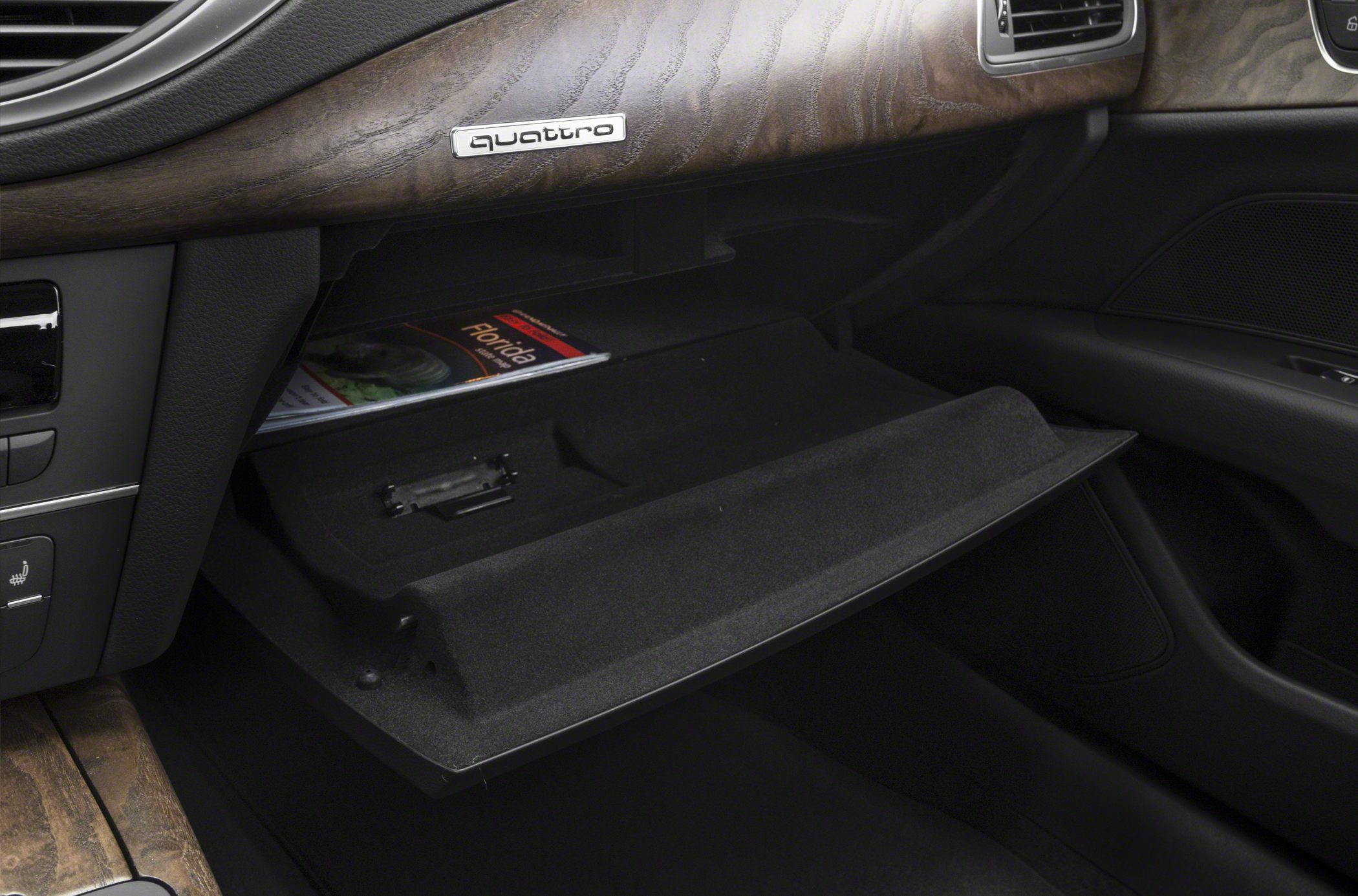 Open glove box with wood trim and quattro badge in luxury car interior