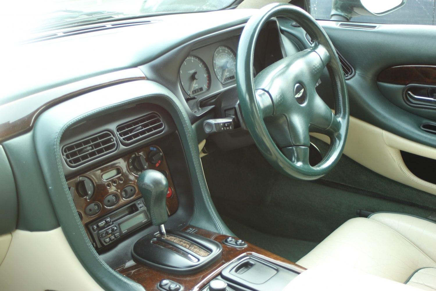 Classic steering wheel with gear shift and wood trim in a luxury vintage car interior