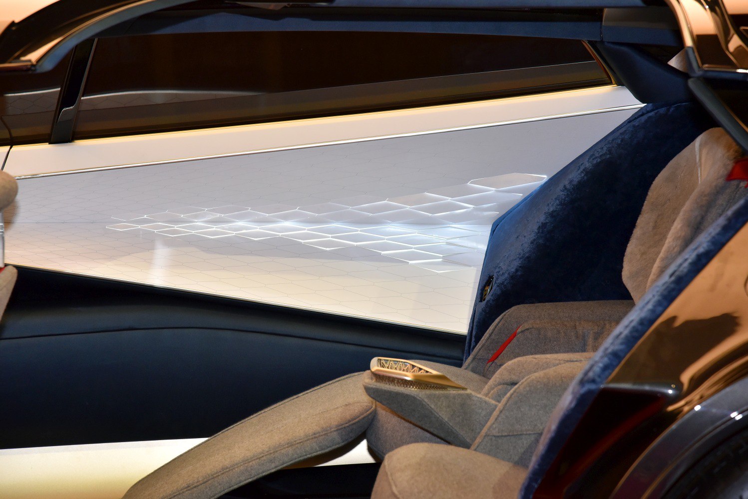 Ambient hexagonal lighting and plush fabric seats in futuristic car interior