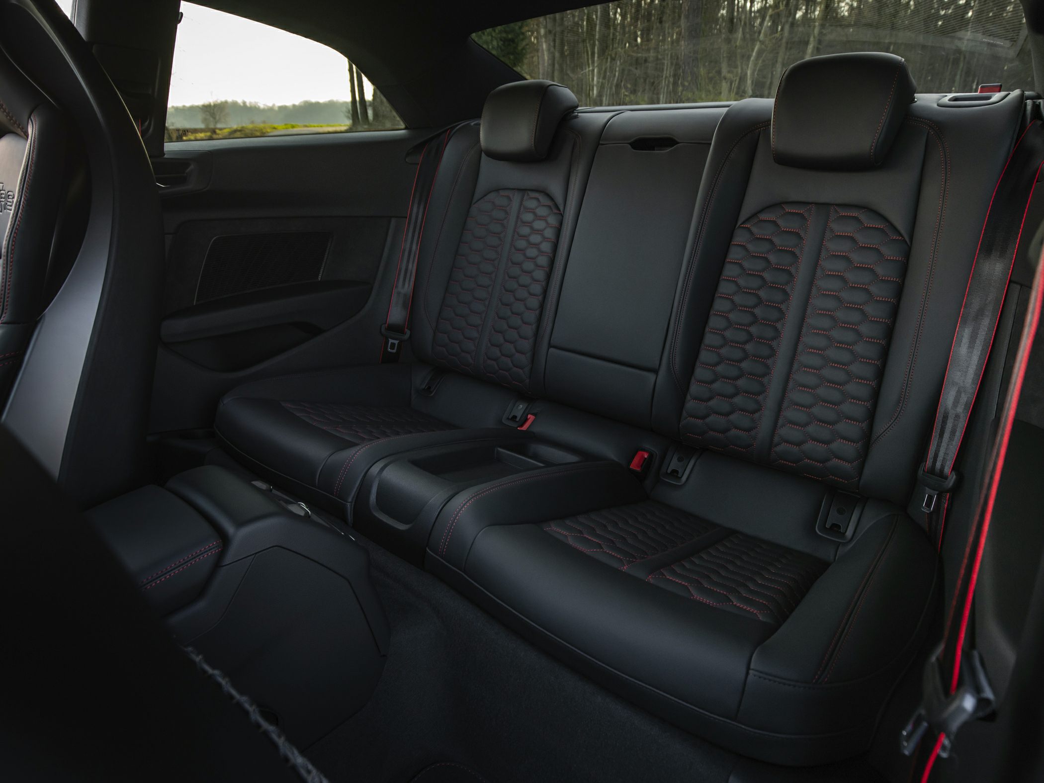 Black leather rear seats with red stitching and honeycomb pattern