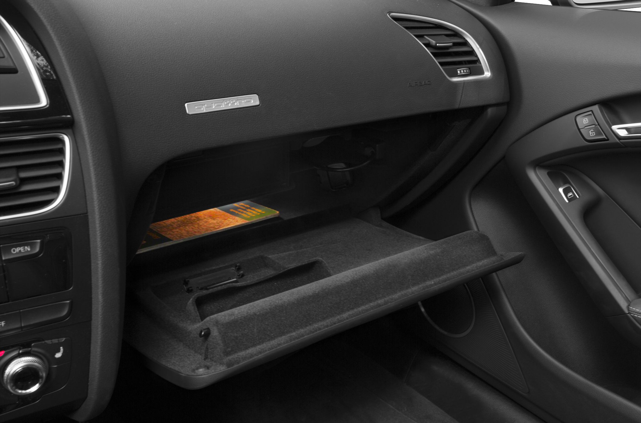 Open glove compartment with Quattro badge and dashboard controls