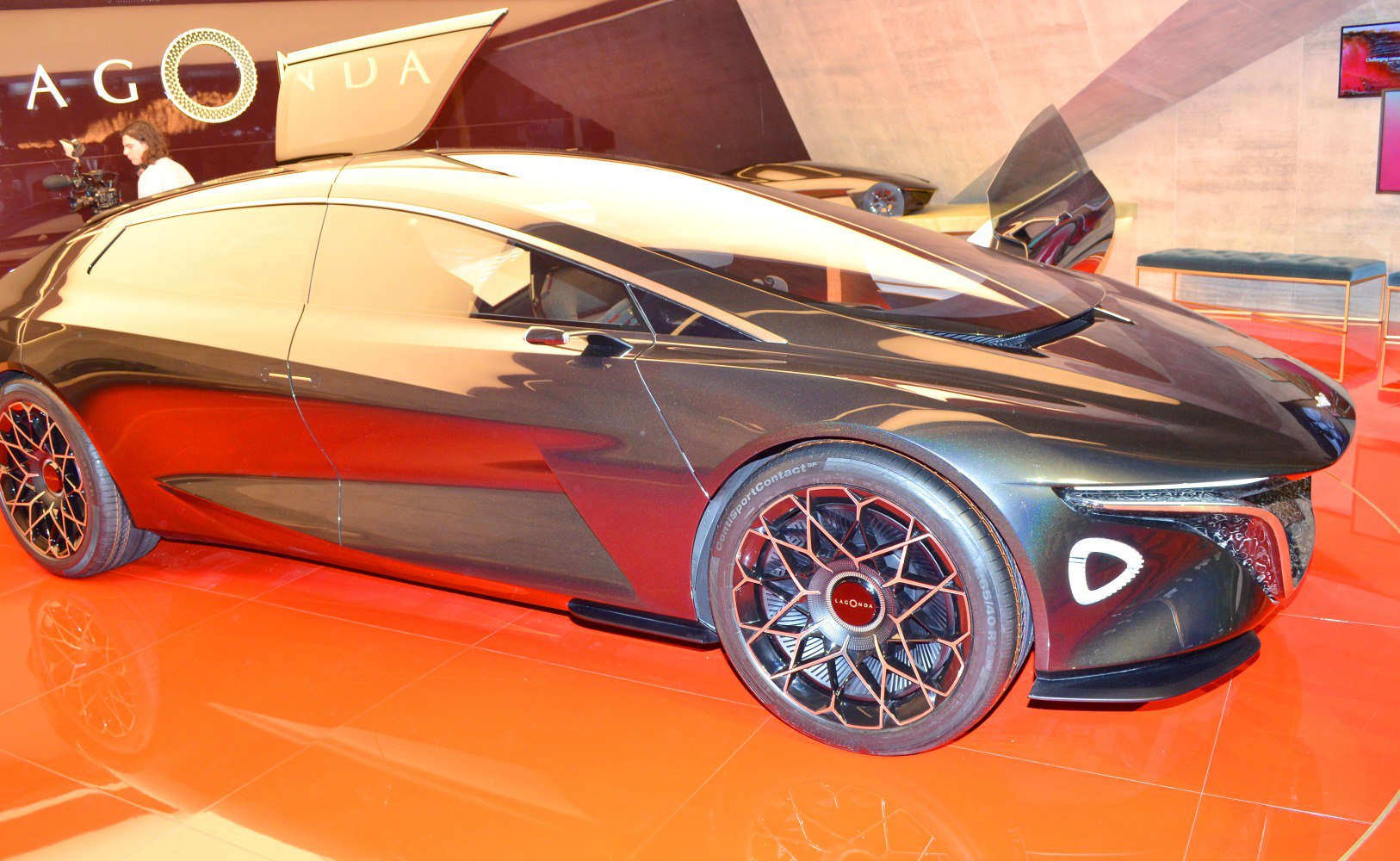 Futuristic aerodynamic sedan with geometric style wheels and unique door design.