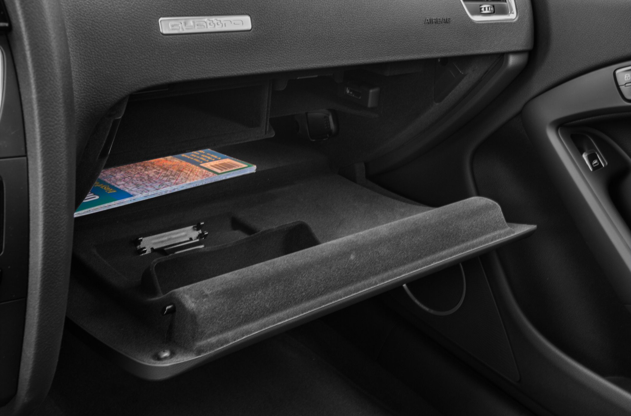 Open glovebox storage compartment with dashboard details
