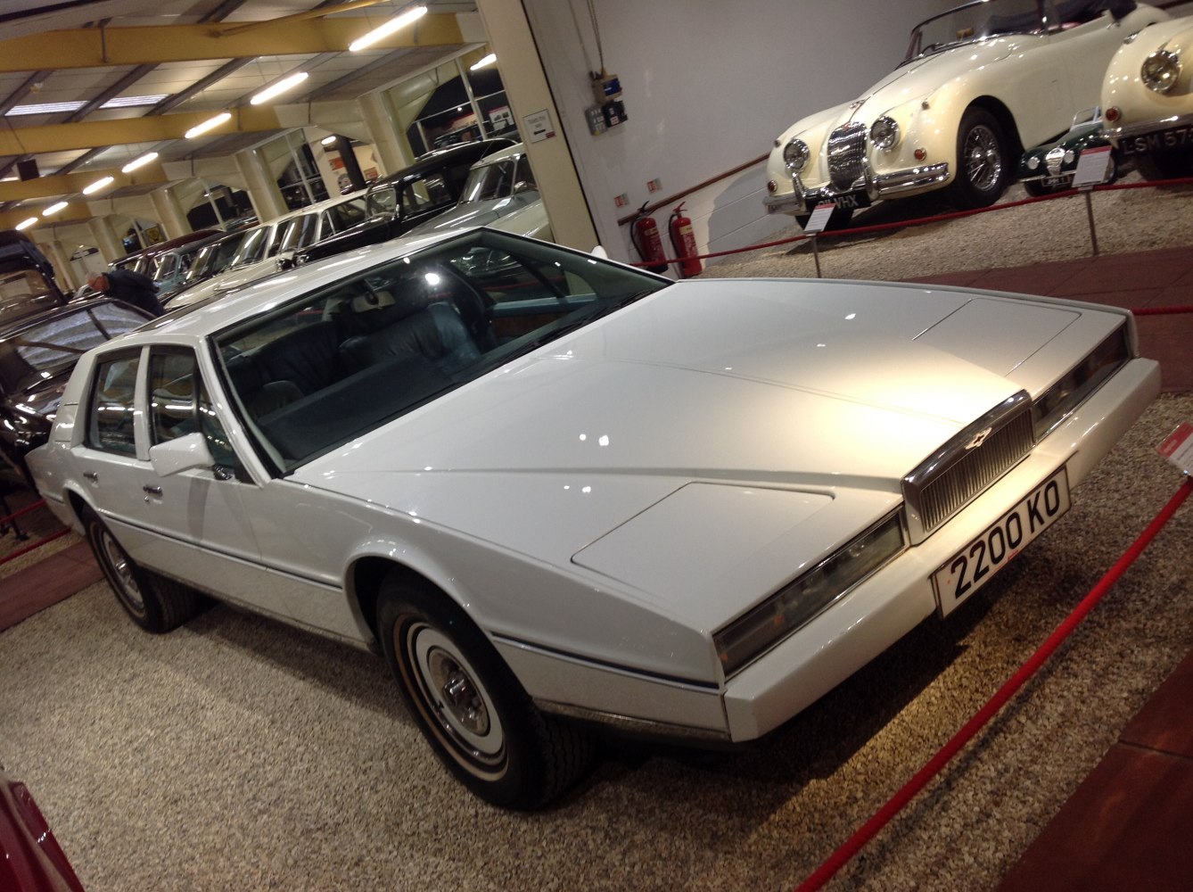 Sleek white luxury coupe with angular body and pop-up headlights