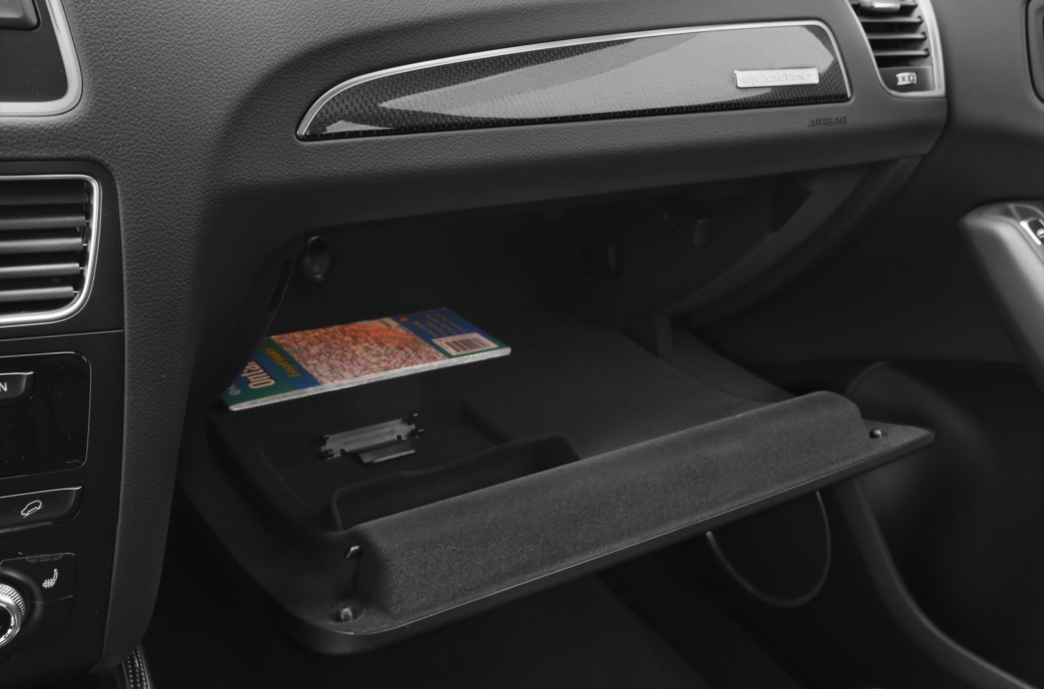 Open glove compartment with map inside in car interior