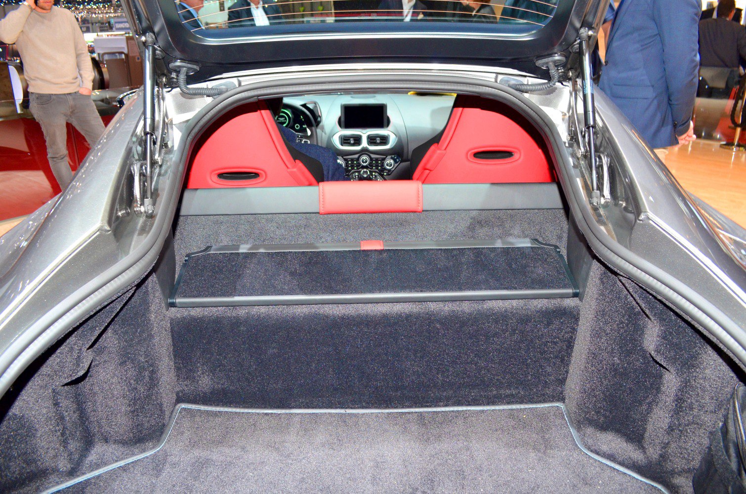 Trunk view with red leather rear seats and dashboard visible.