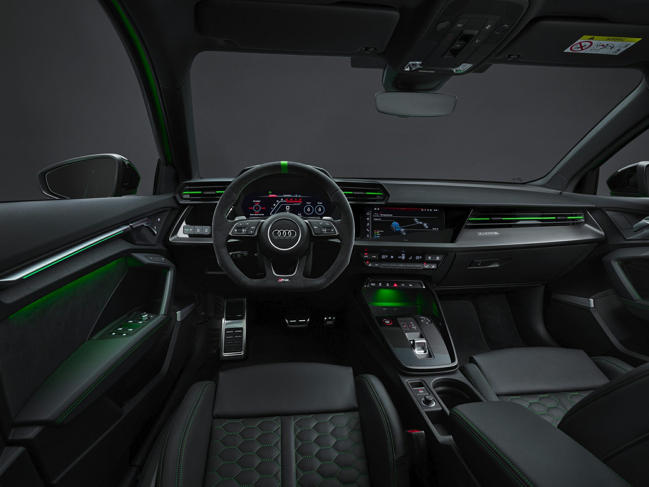 Sporty steering wheel and digital dashboard with green ambient lighting.