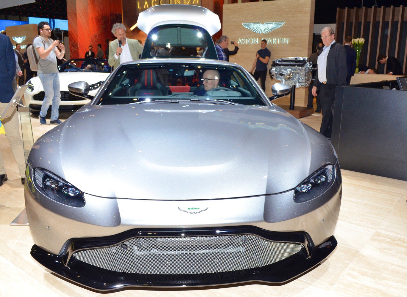 Front view with sleek headlights and open rear trunk at auto show