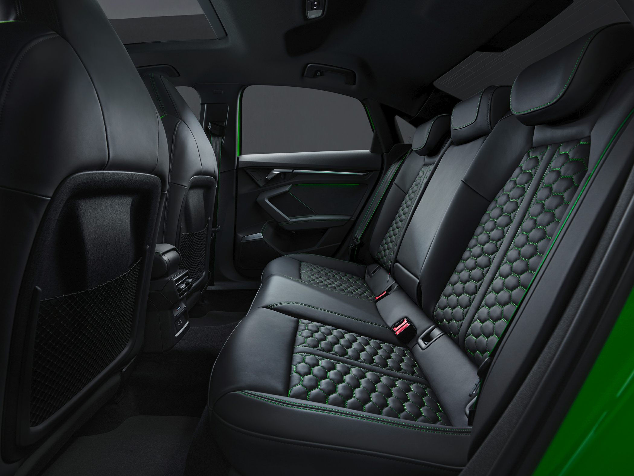 Rear black leather seats with green hexagonal stitching