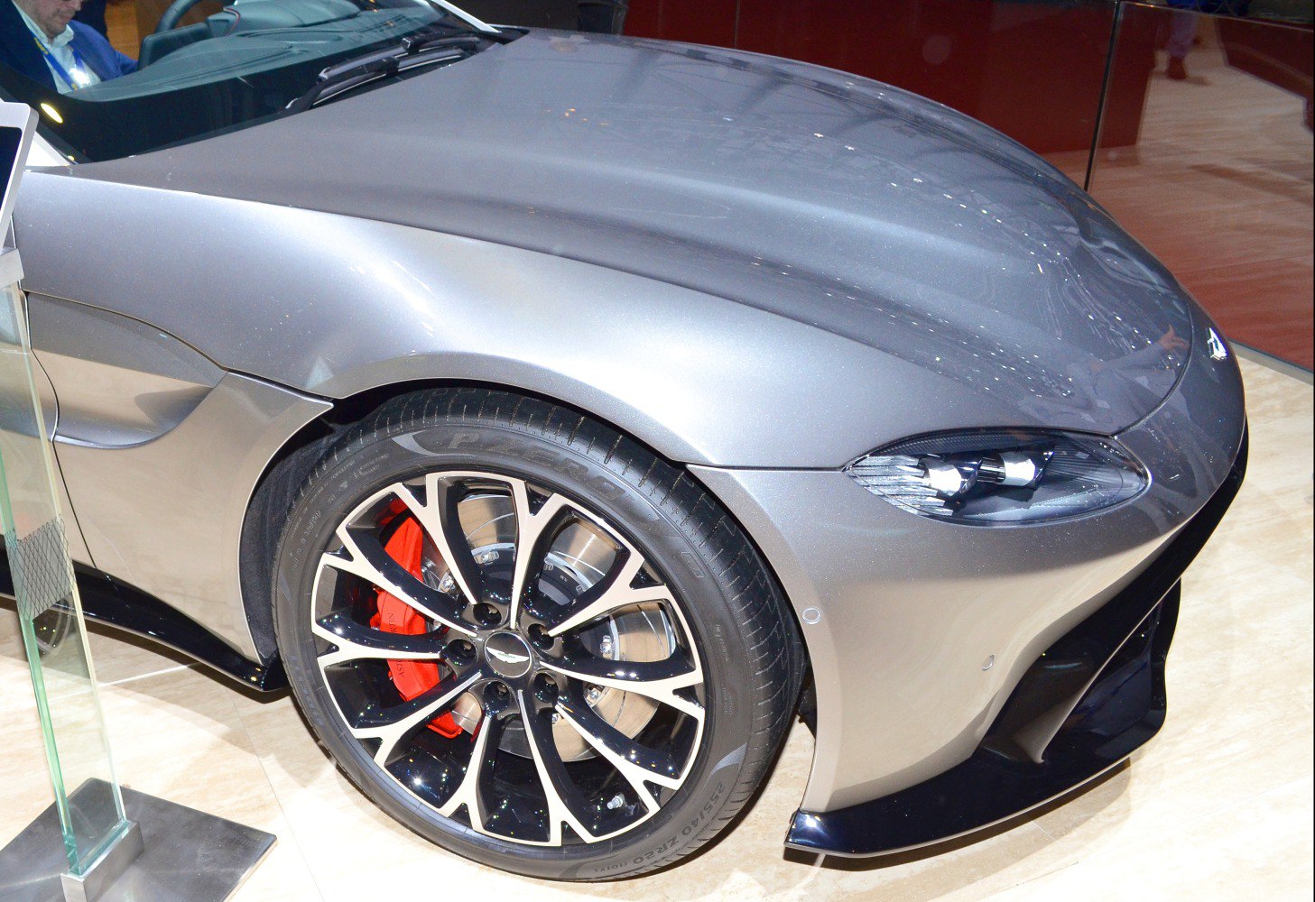 Front wheel with alloy rim and red brake caliper, sleek car headlight