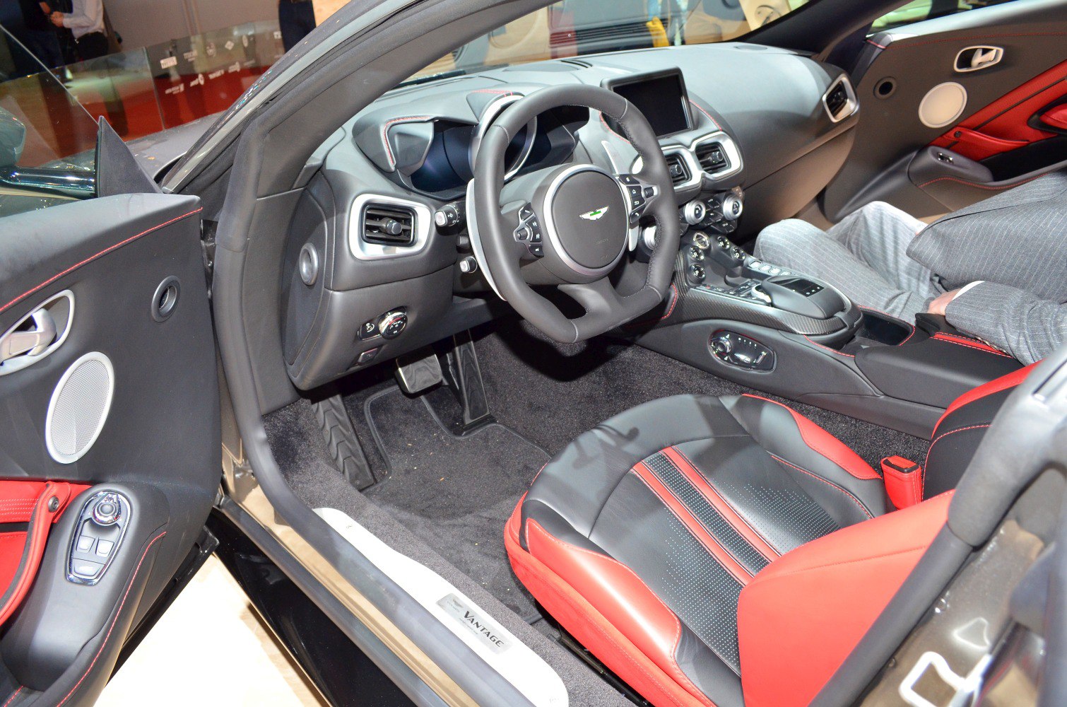 Luxury interior with black and red leather seats, modern dashboard, and steering wheel.