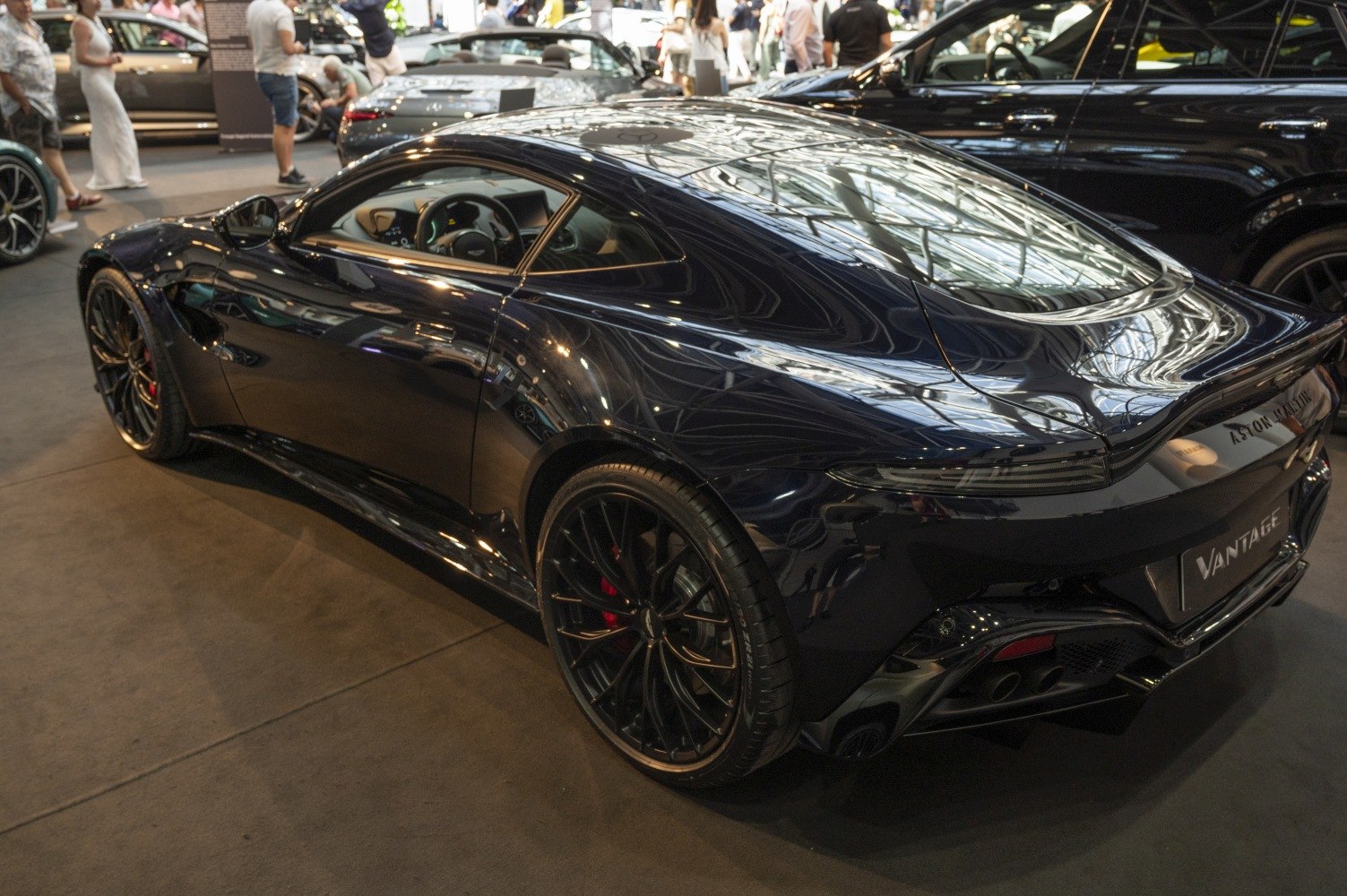Rear side profile of a sleek sports coupe with black alloy wheels and aerodynamic design