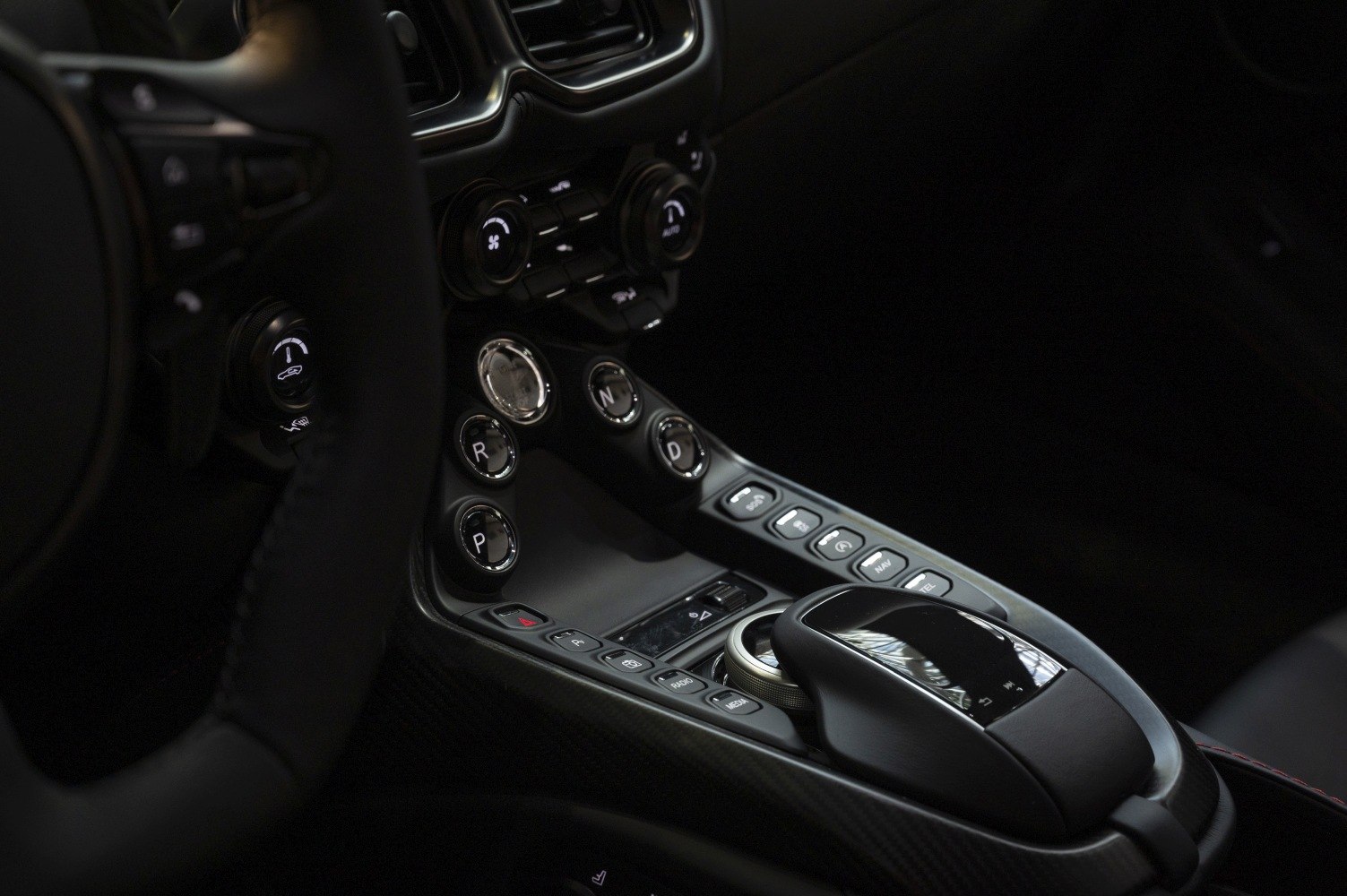 Gear selector buttons and center console controls with climate knobs