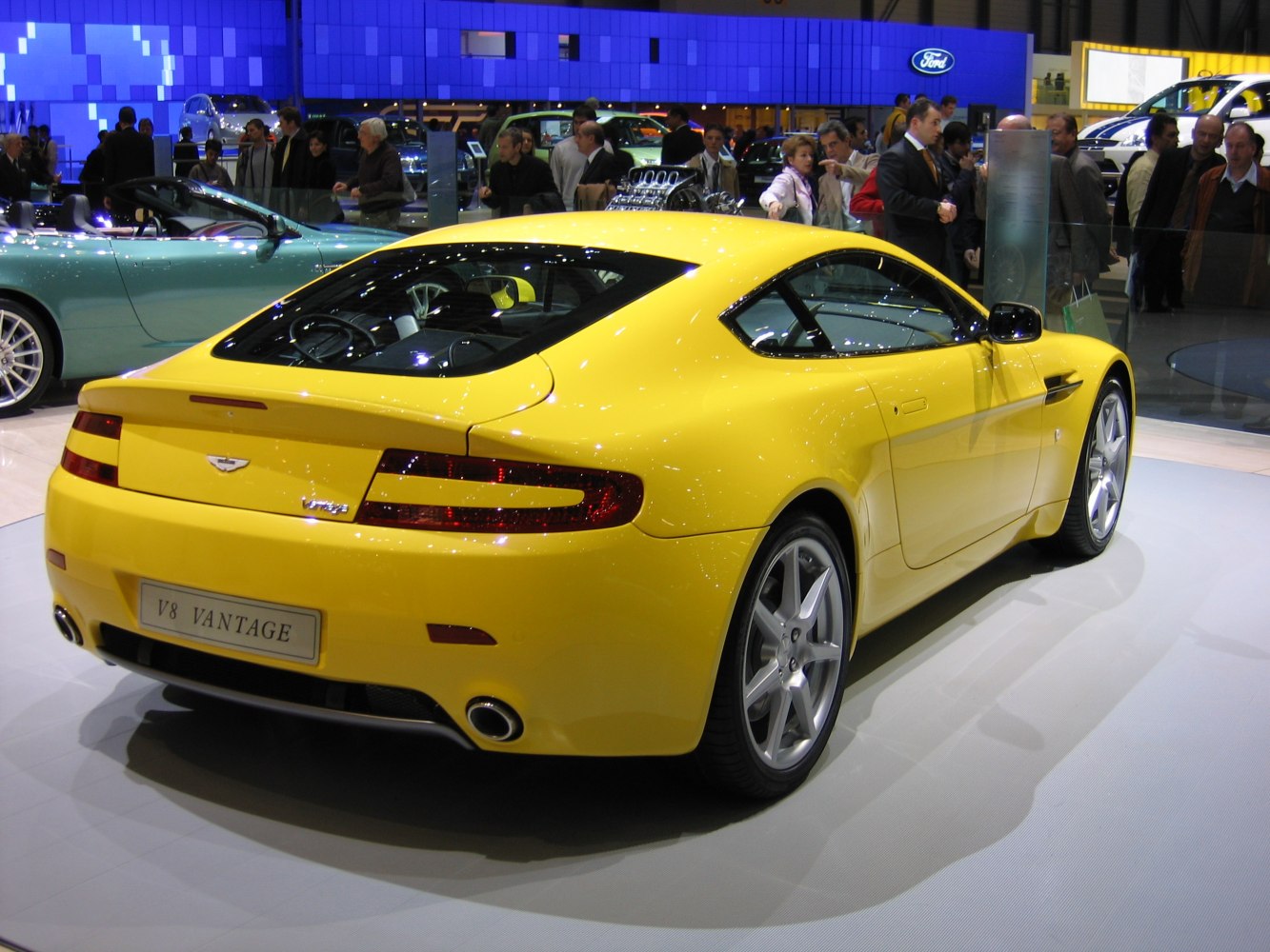 Yellow sports coupe rear-side view with distinctive tail lights and sleek design
