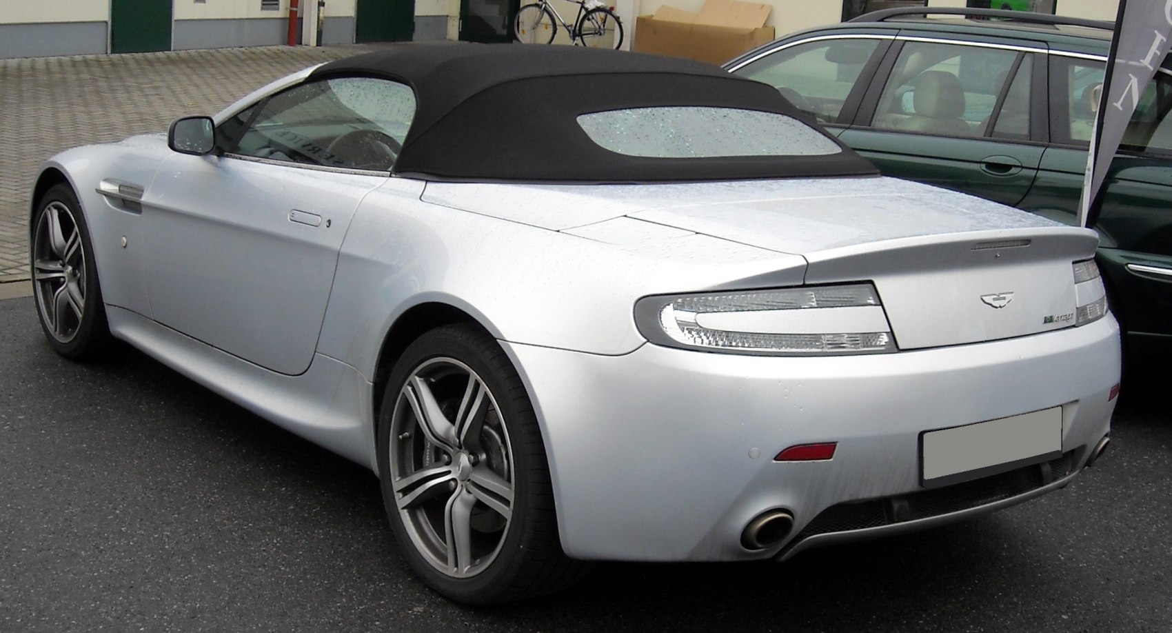 Rear side view of silver convertible with black soft top roof