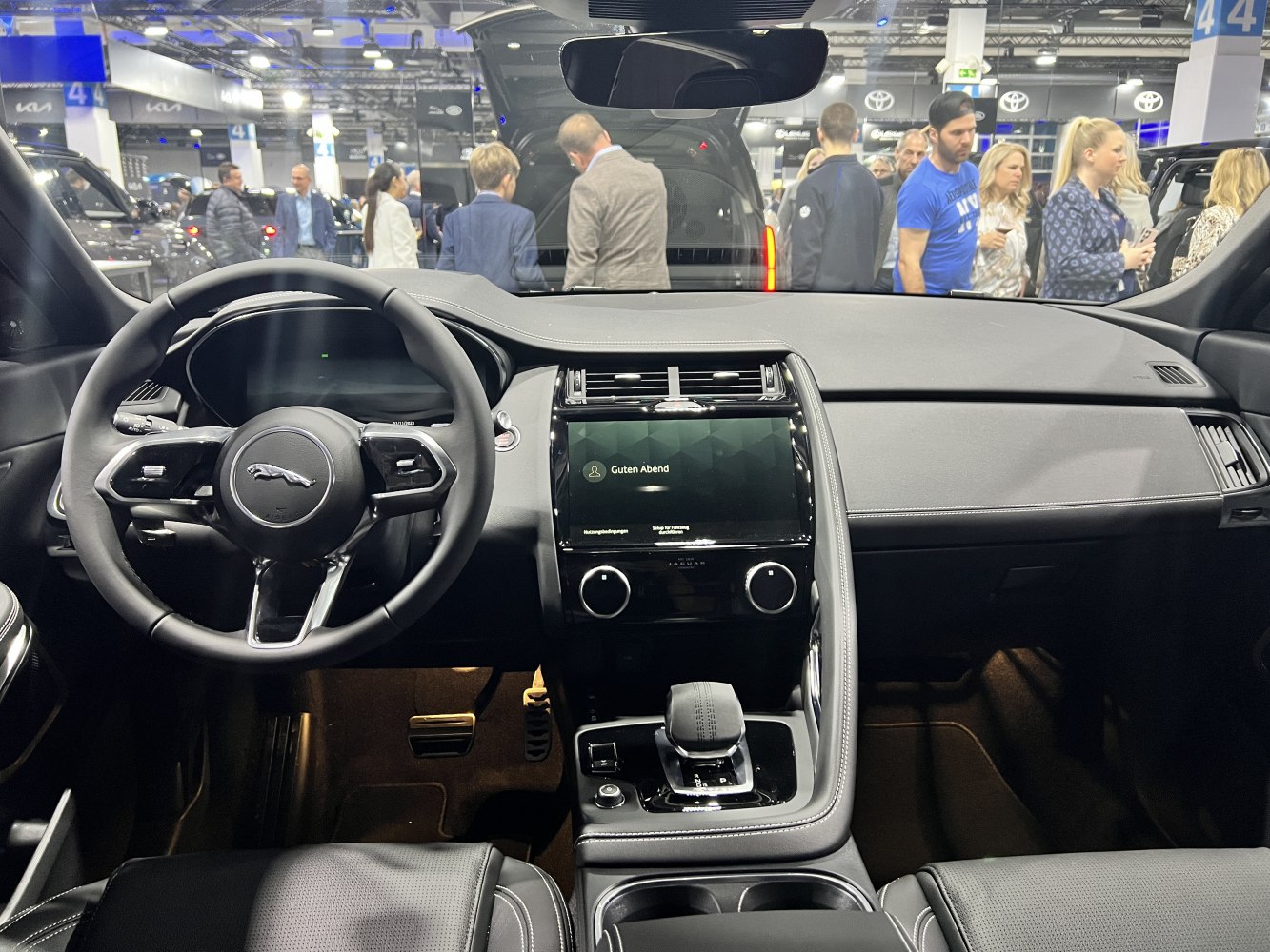 Dashboard and steering wheel with touchscreen interface and gear shifter.
