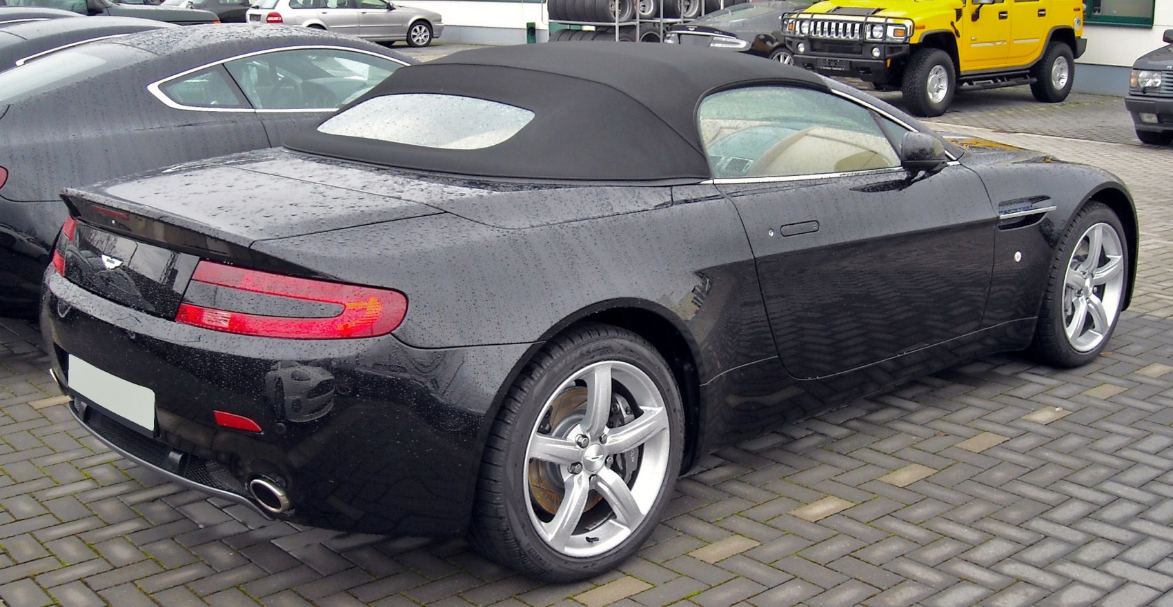 Rear 3-4 view of a sleek convertible with soft-top and alloy wheels