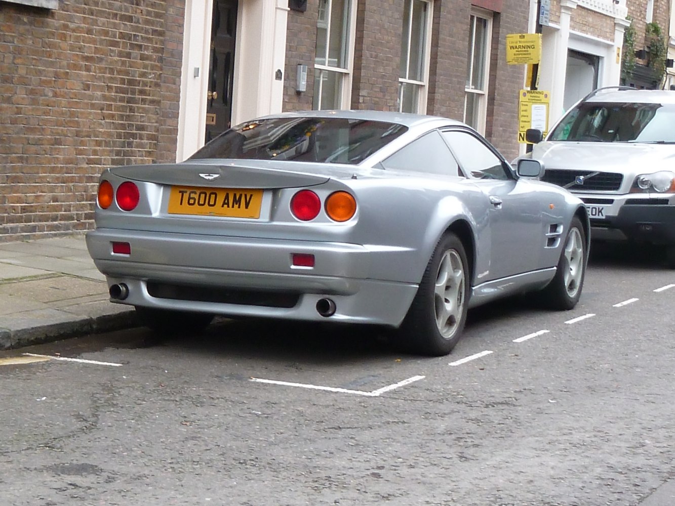 Silver coupe rear with round tail lights and dual exhaust