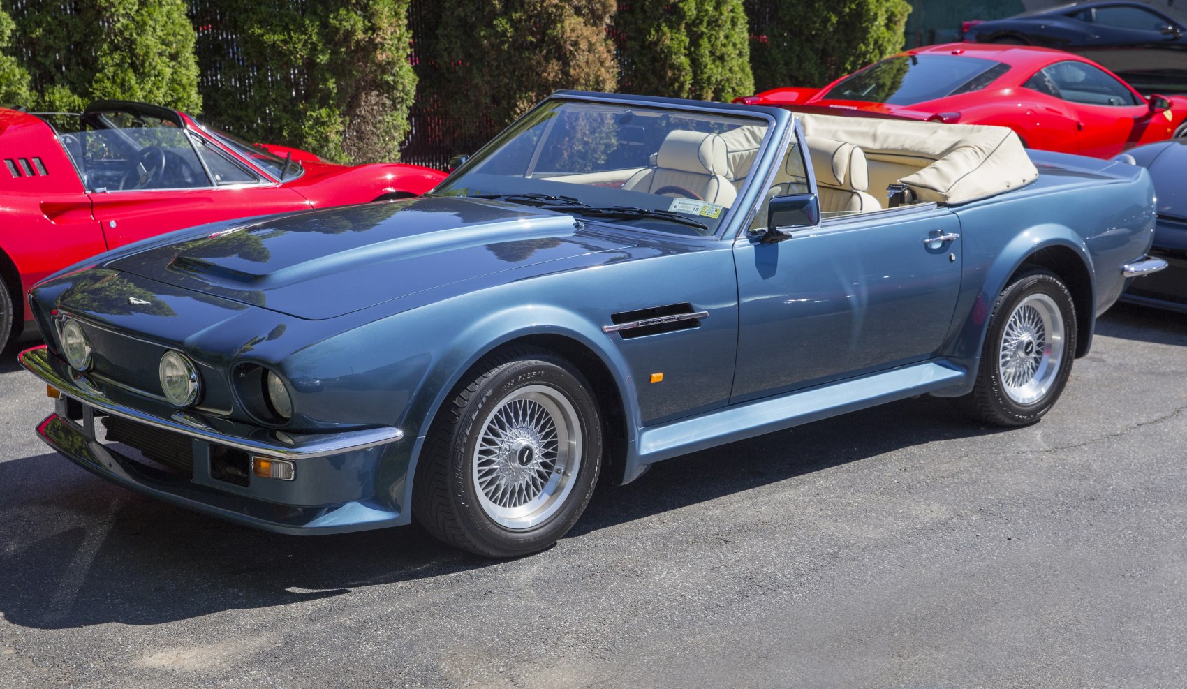 Classic convertible with hood scoop and wire wheels in blue, cream interior.