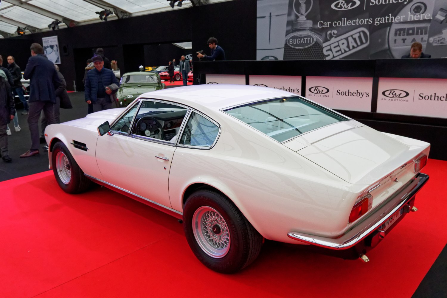 White classic sports coupe with wire wheels and sleek rear design